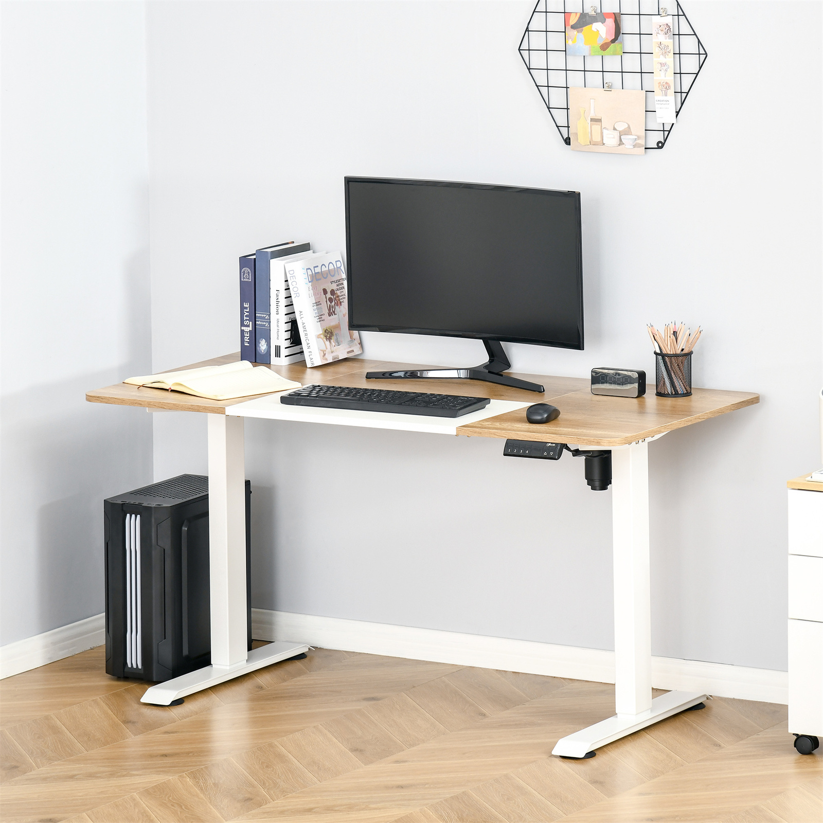 Ein Schreibtisch mit Computer und Monitor, mit Büchern und Zubehör. Ein Fenster im Hintergrund und ein Stifthalter.