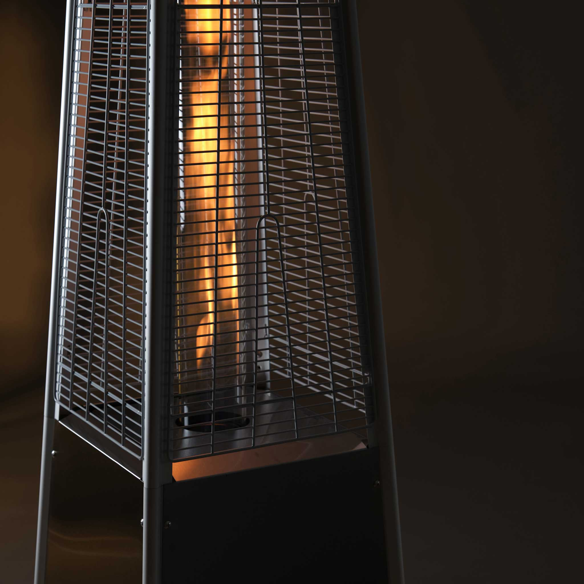 Wysoki grzejnik zewnętrzny z widocznym płomieniem.