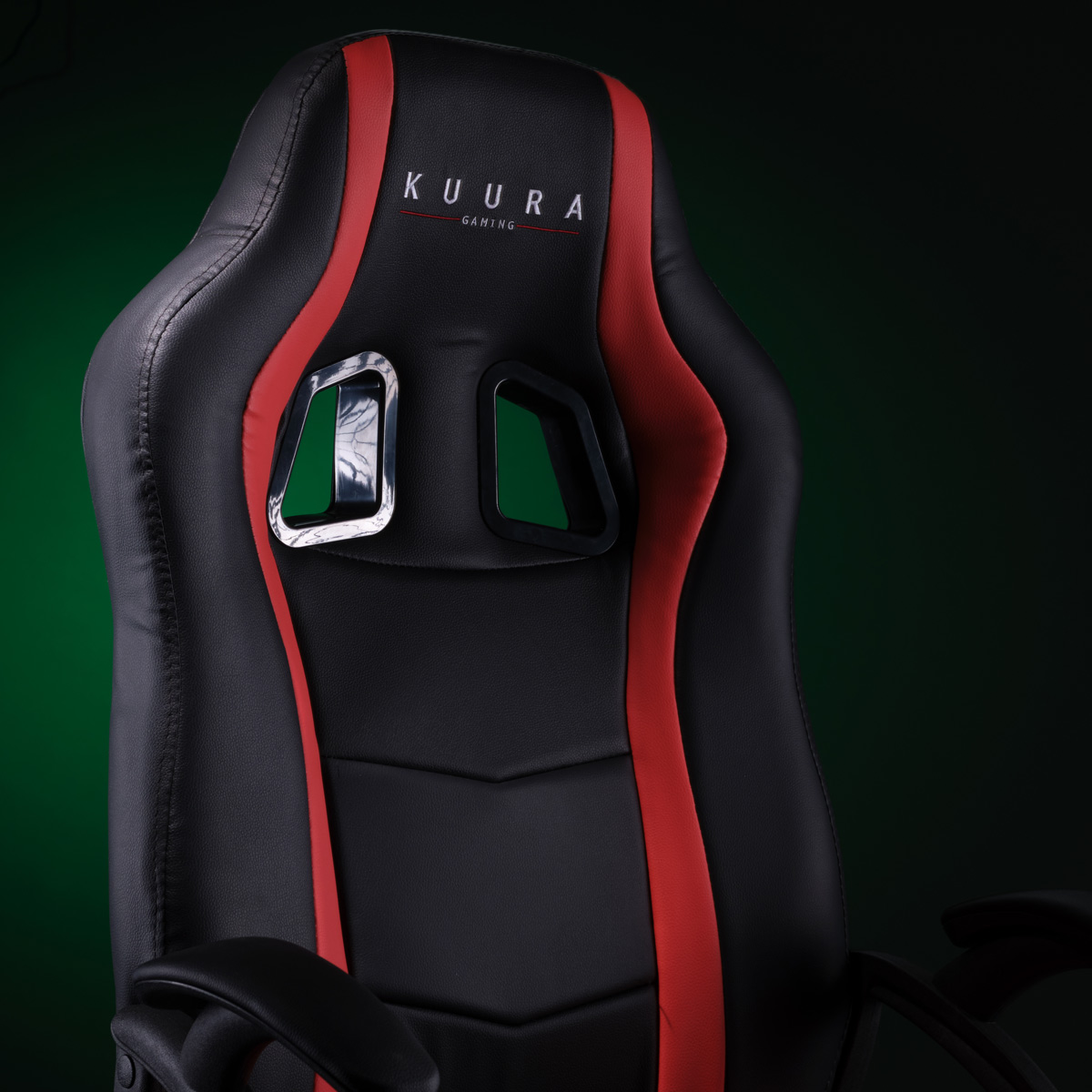 Schwarz-roter Gaming-Stuhl. Rote Akzente. KUURA Gaming Logo. Vor grünem Hintergrund.