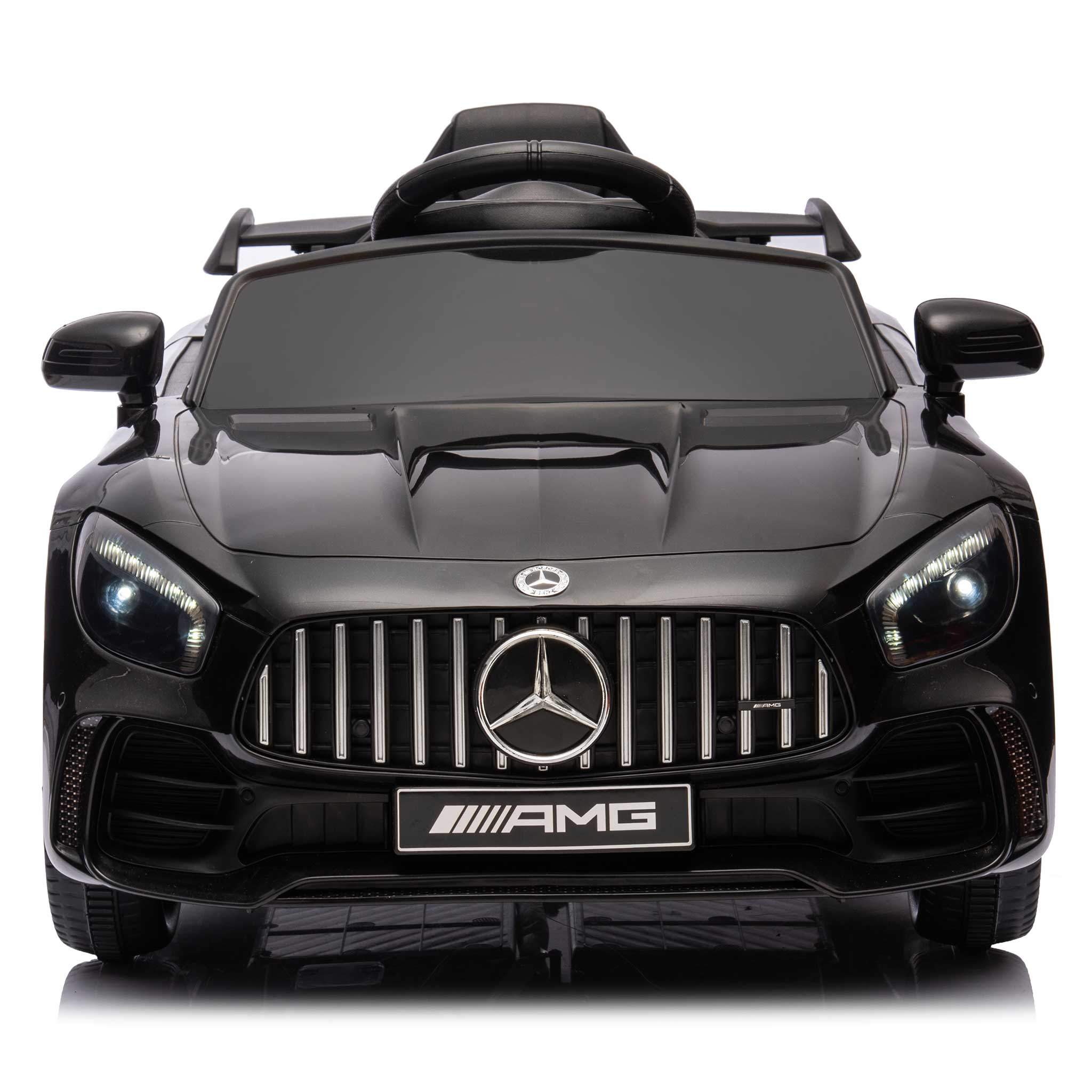 Ein schwarzes Mercedes-Benz AMG Elektro-Spielzeugauto mit eingeschalteten Scheinwerfern.