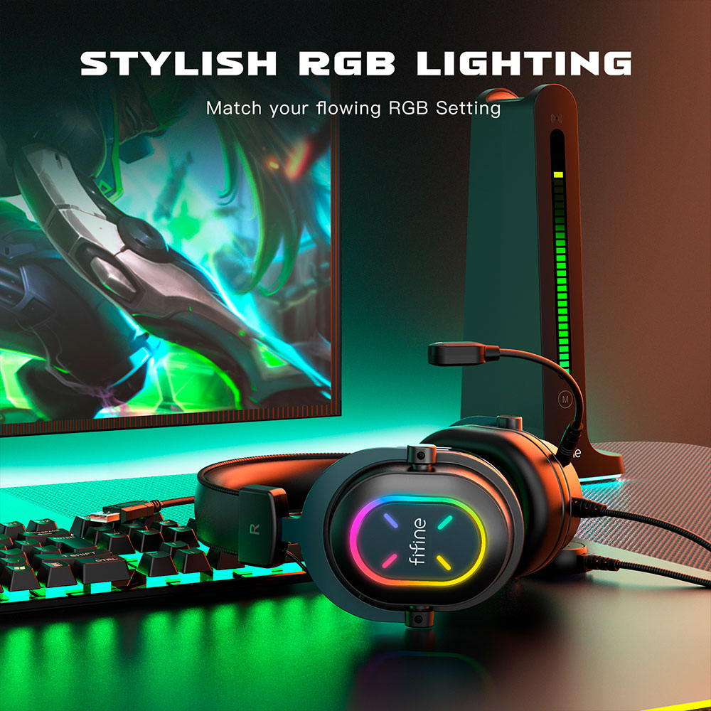 Cuffie nere con luci RGB, tastiera e monitor sullo sfondo. Illuminazione verde e arancione.