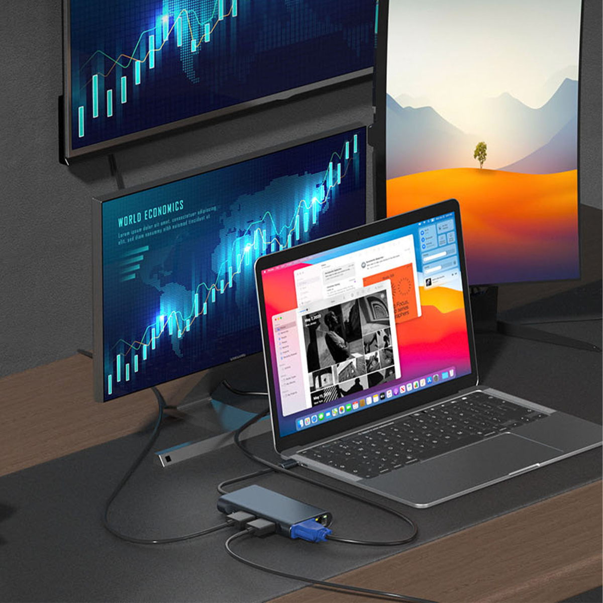 Laptop, zwei Monitore und ein Hub auf einem Schreibtisch. Zeigt Grafiken und Website.