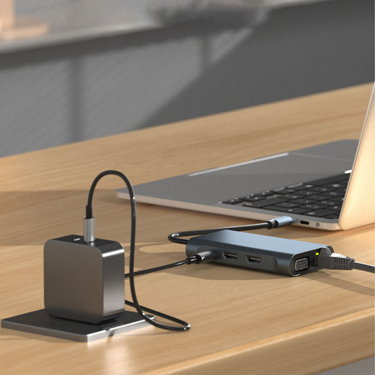 USB-C-Hub mit Laptop verbunden. Hub hat Anschlüsse. Schwarzes Netzteil und Ständer auf Holzschreibtisch. Seitenansicht.