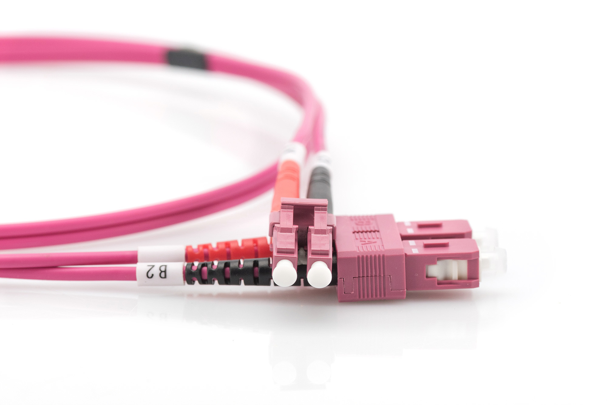 Cavo in fibra ottica rosa con connettori. Sfondo bianco.
