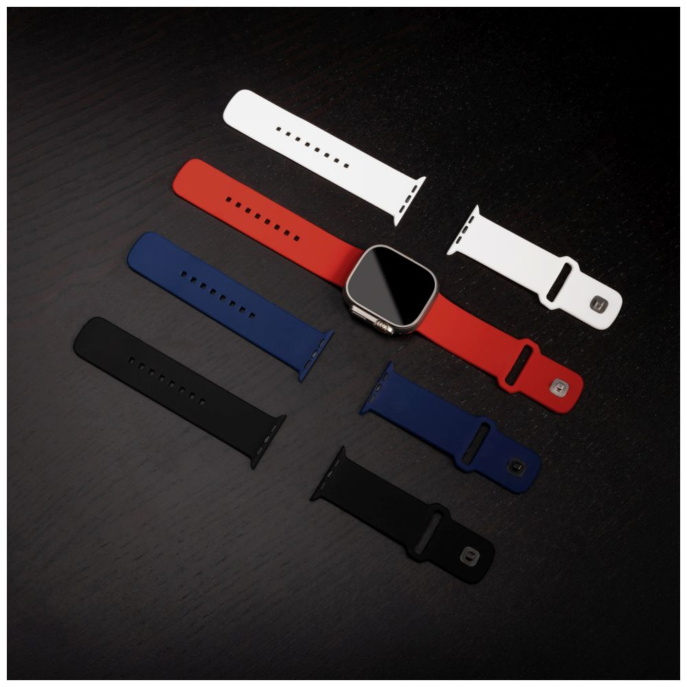 Uhr mit roten, blauen, schwarzen und weißen Armbändern auf dunkler Holzoberfläche.
