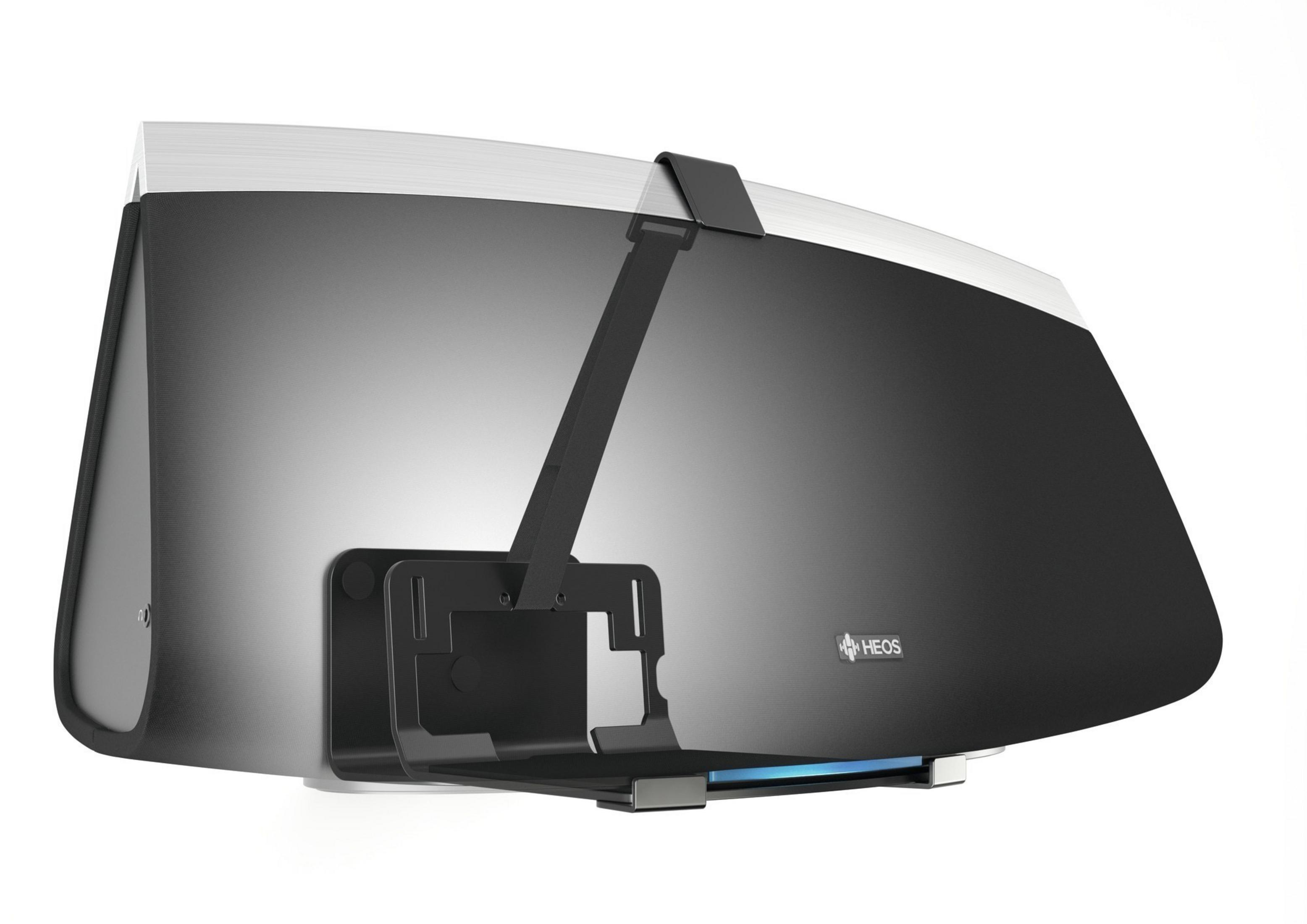 Czarny i srebrny głośnik Heos z uchwytem. Głośnik jest zamontowany na białej ścianie.