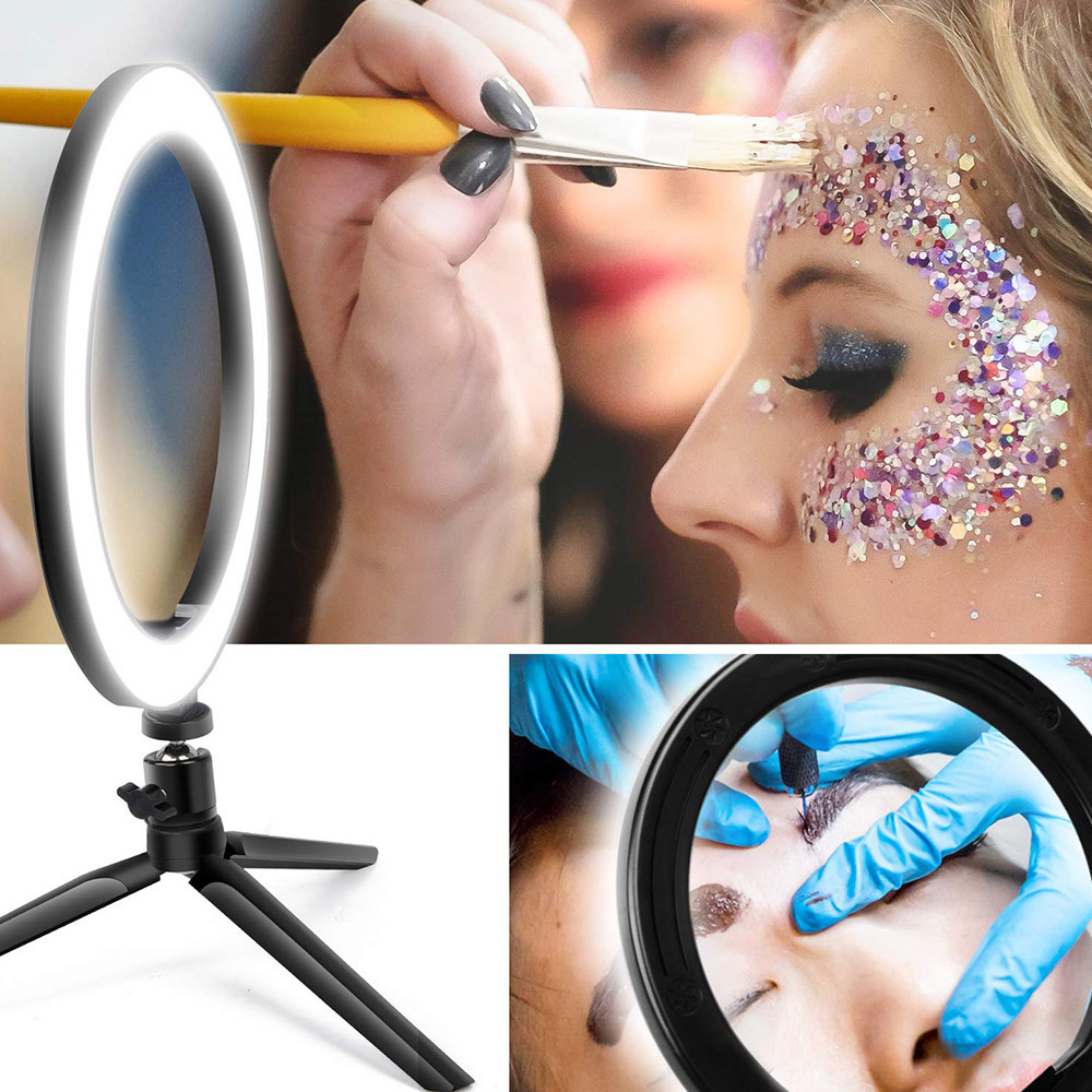 Make-up-Anwendung: Ringlicht, Künstlerin trägt Glitzer auf das Gesicht auf, Nahaufnahme der Augenbrauen.