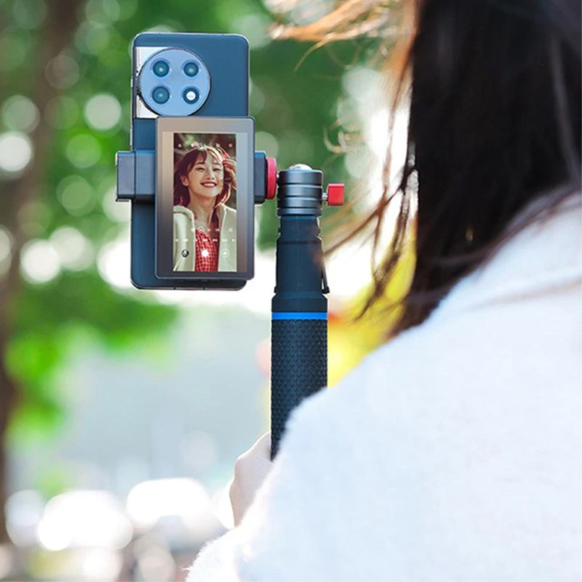 Una persona sosteniendo un teléfono con grabación de video selfie en un gimbal.