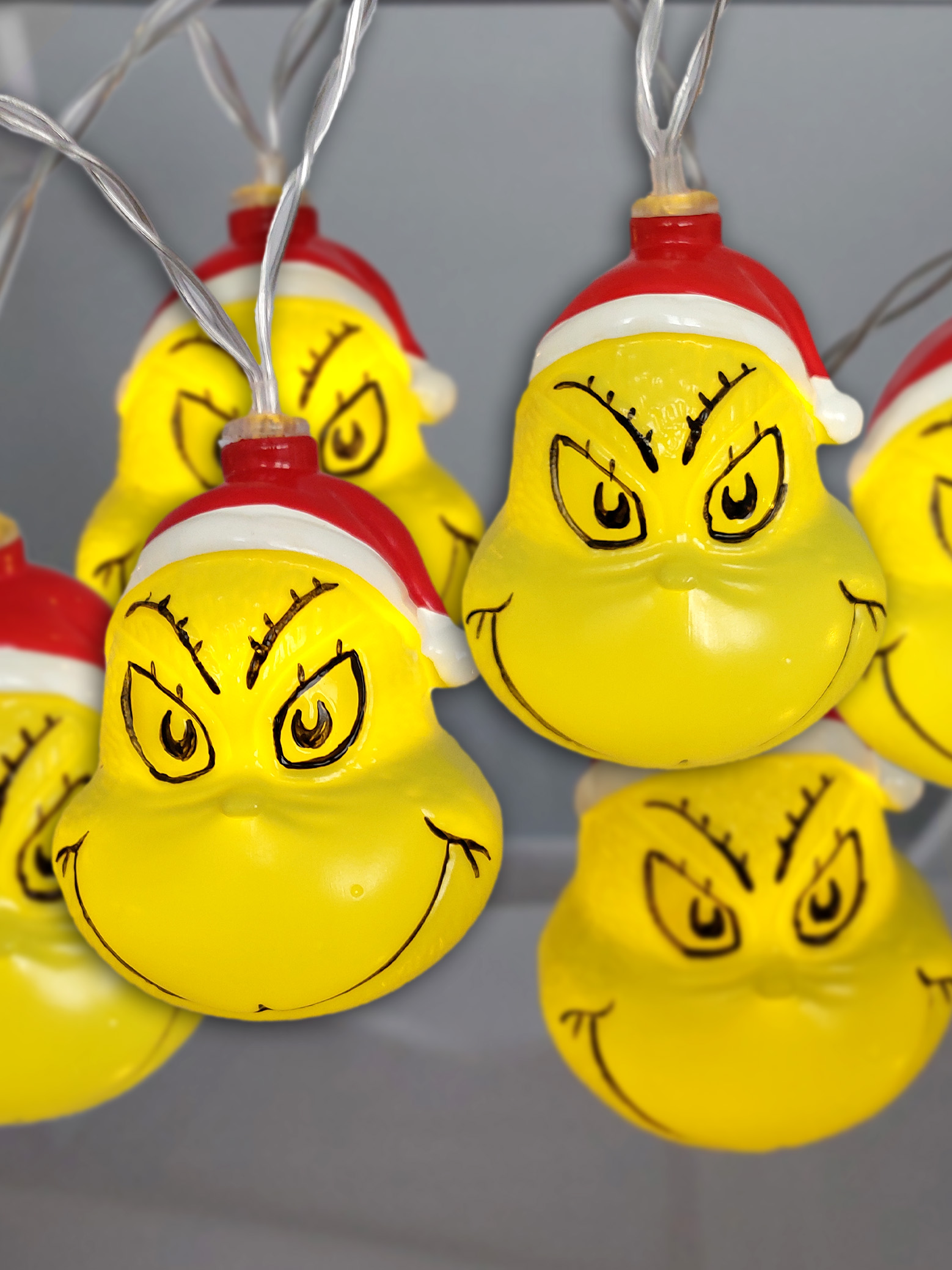 Weihnachtsbeleuchtung, Grinch-förmig, gelb mit roten Hüten.