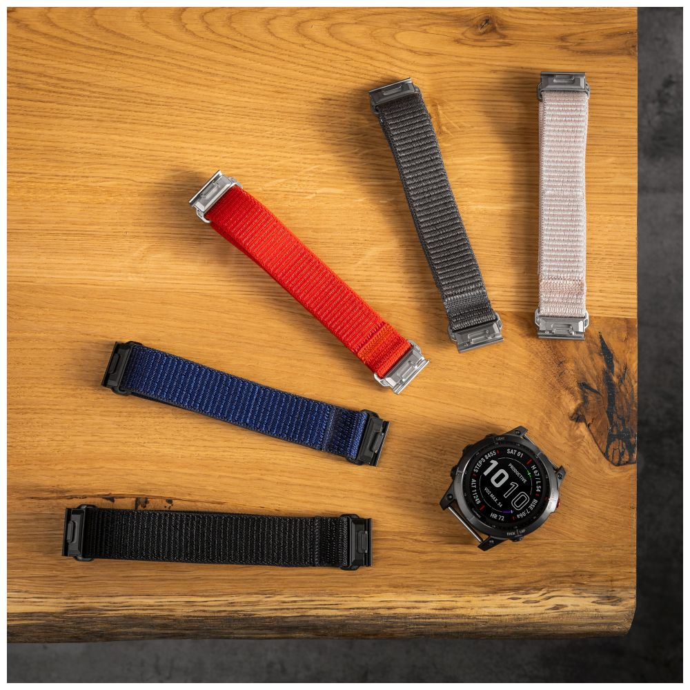 Holztisch mit Uhr und bunten Uhrenarmbändern.