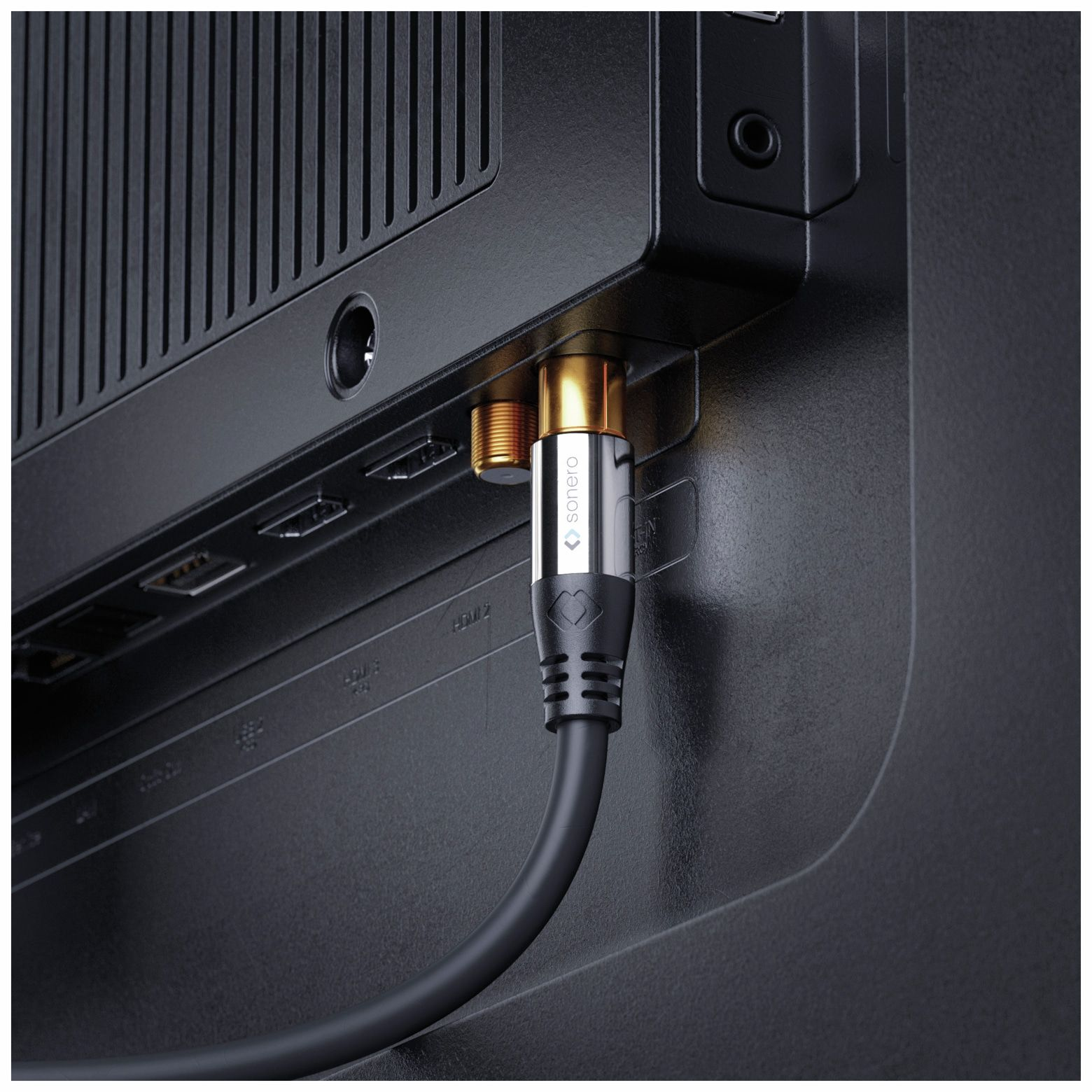 Kabel an einen Fernseher angeschlossen. Das Kabel ist schwarz, mit goldenem Stecker und schwarzem TV.