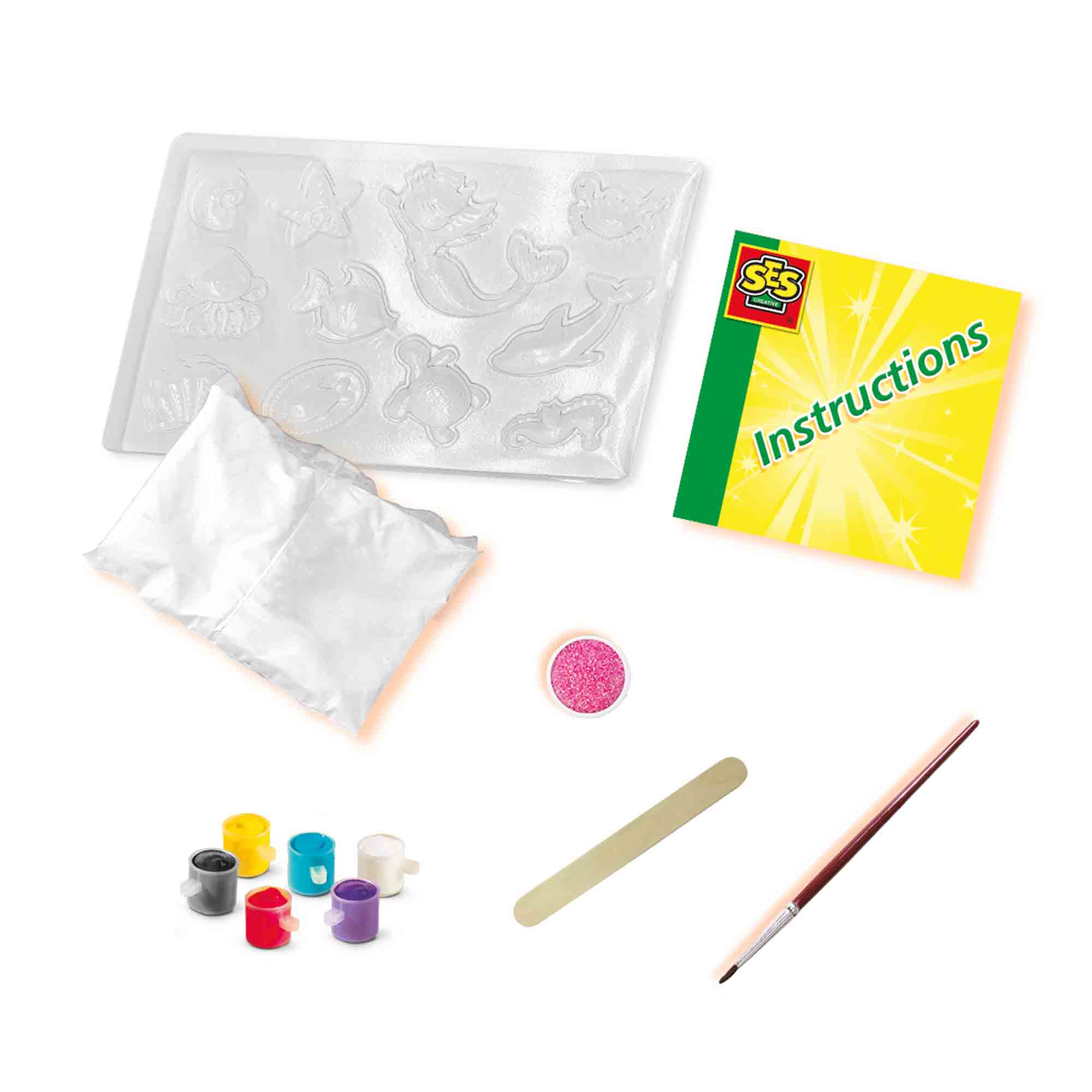 Zestaw rzemieślniczy z formami, farbą, pędzlem, brokatem i instrukcjami na białym tle.