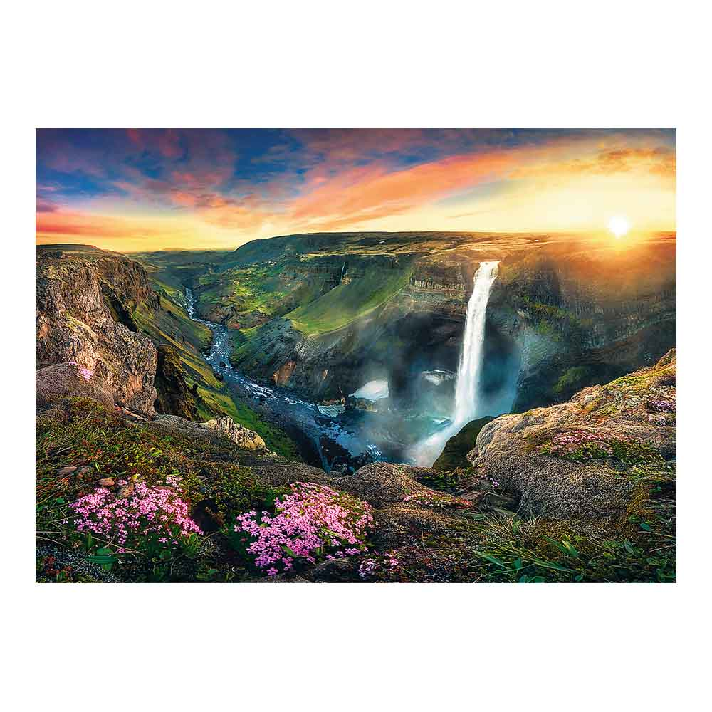Wodospad w kanionie z różowymi kwiatami na pierwszym planie i zachodem słońca.