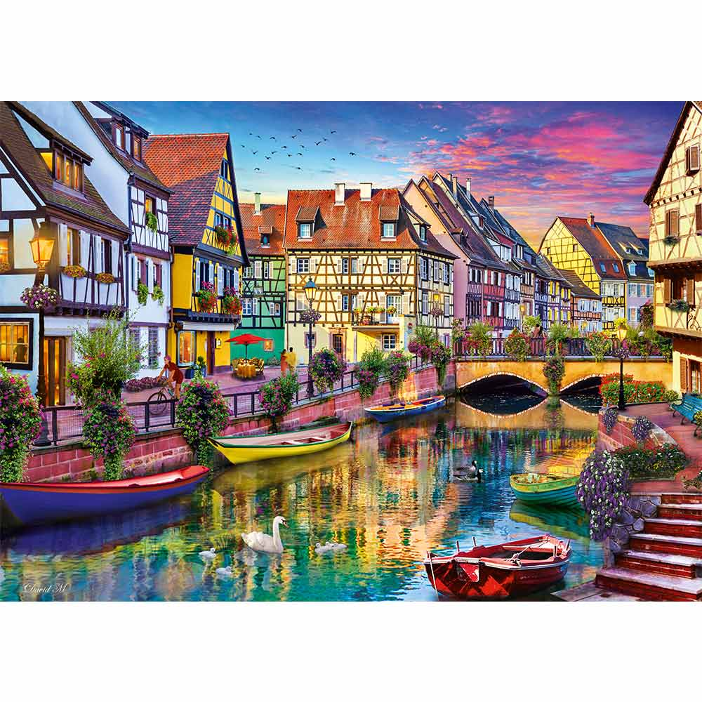 Scène de canal avec bâtiments colorés, bateaux et reflets sur l'eau, sous un ciel de coucher de soleil.
