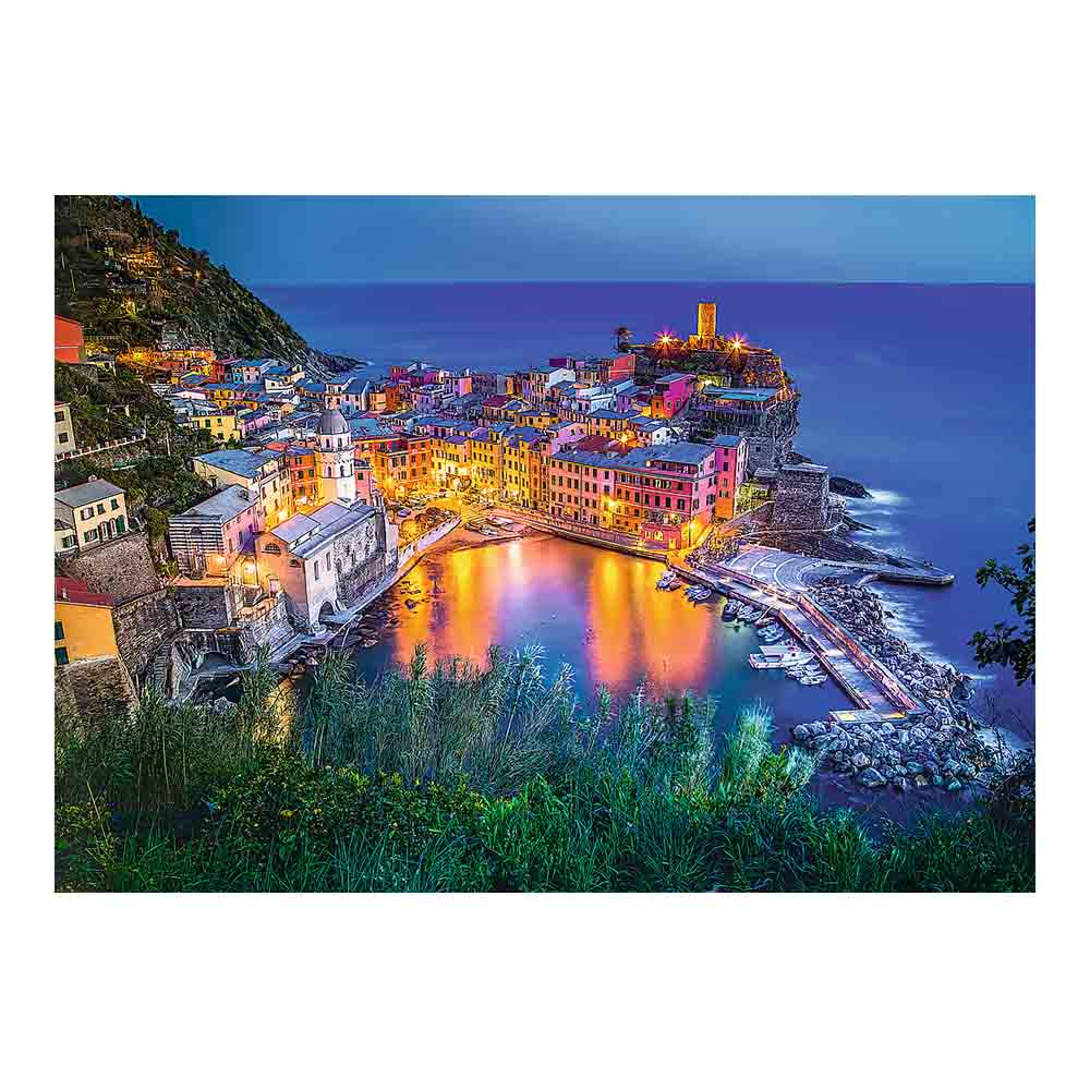 Nadbrzeżna wioska o zmierzchu, kolorowe budynki, odbicie w wodzie, łodzie i wieża po prawej.