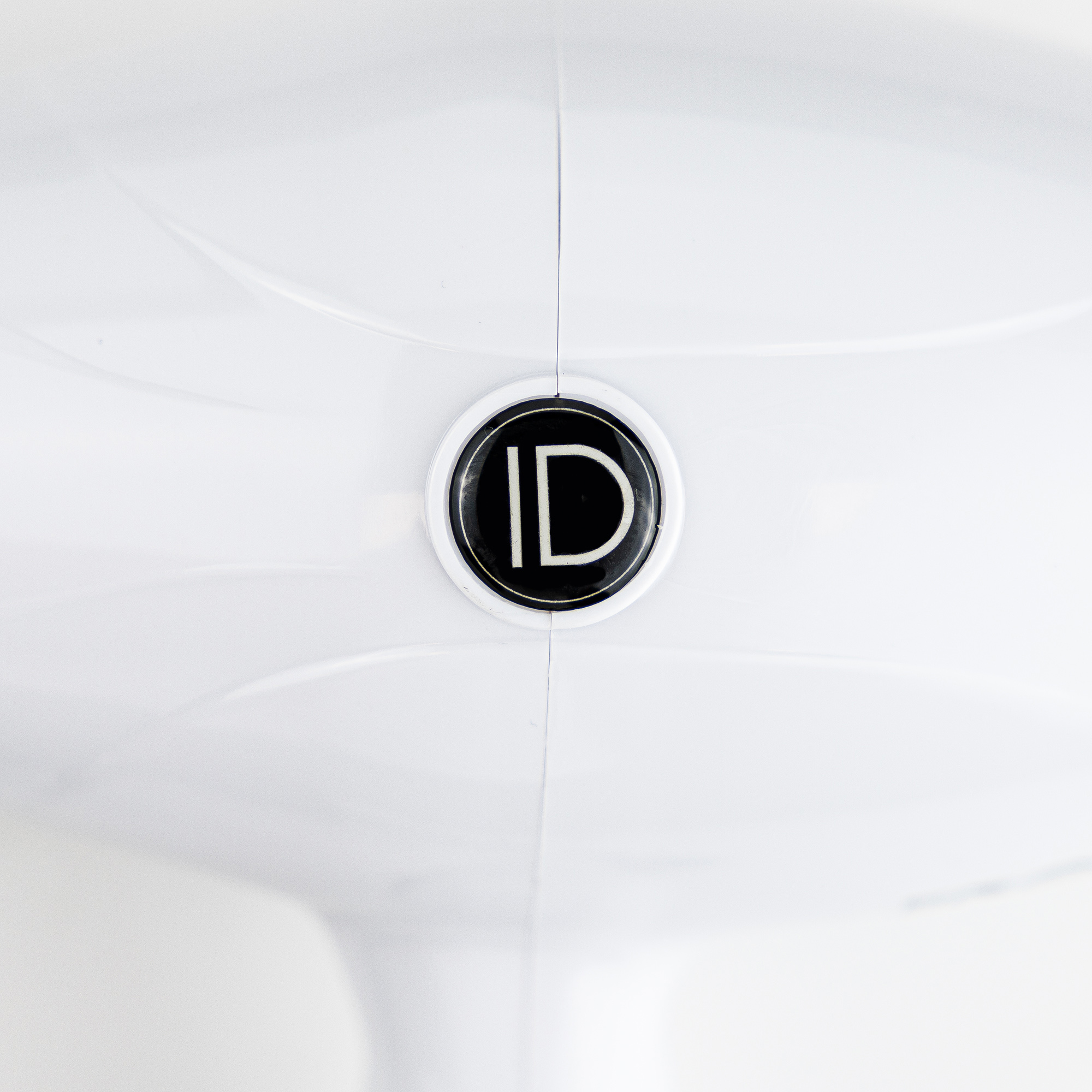 Zbliżenie białego obiektu z czarno-białym okrągłym logo. Logo mówi "ID".