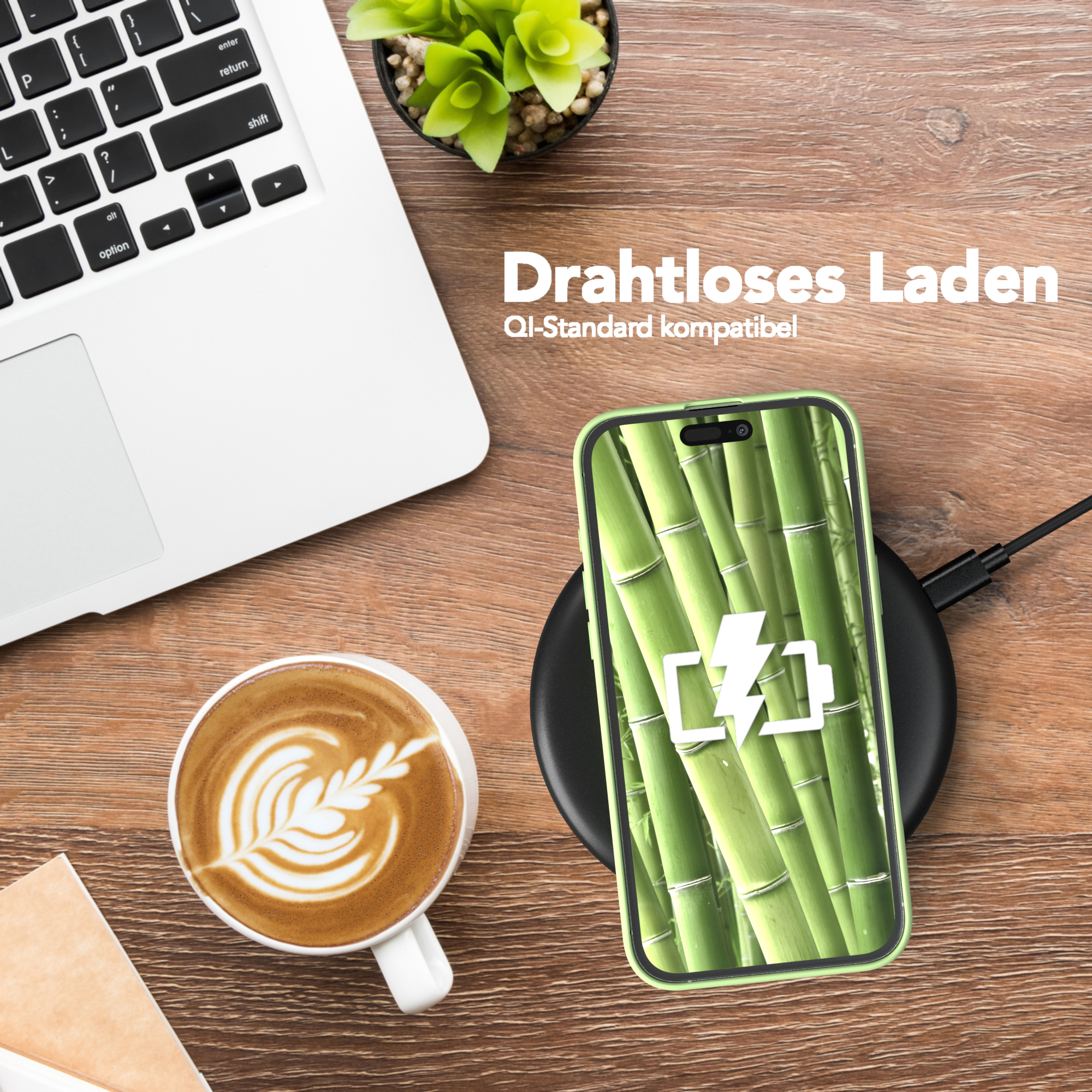 Laptop, Kaffee, kabelloses Aufladen des Telefons. Grüne Handyhülle zeigt Bambusbild.