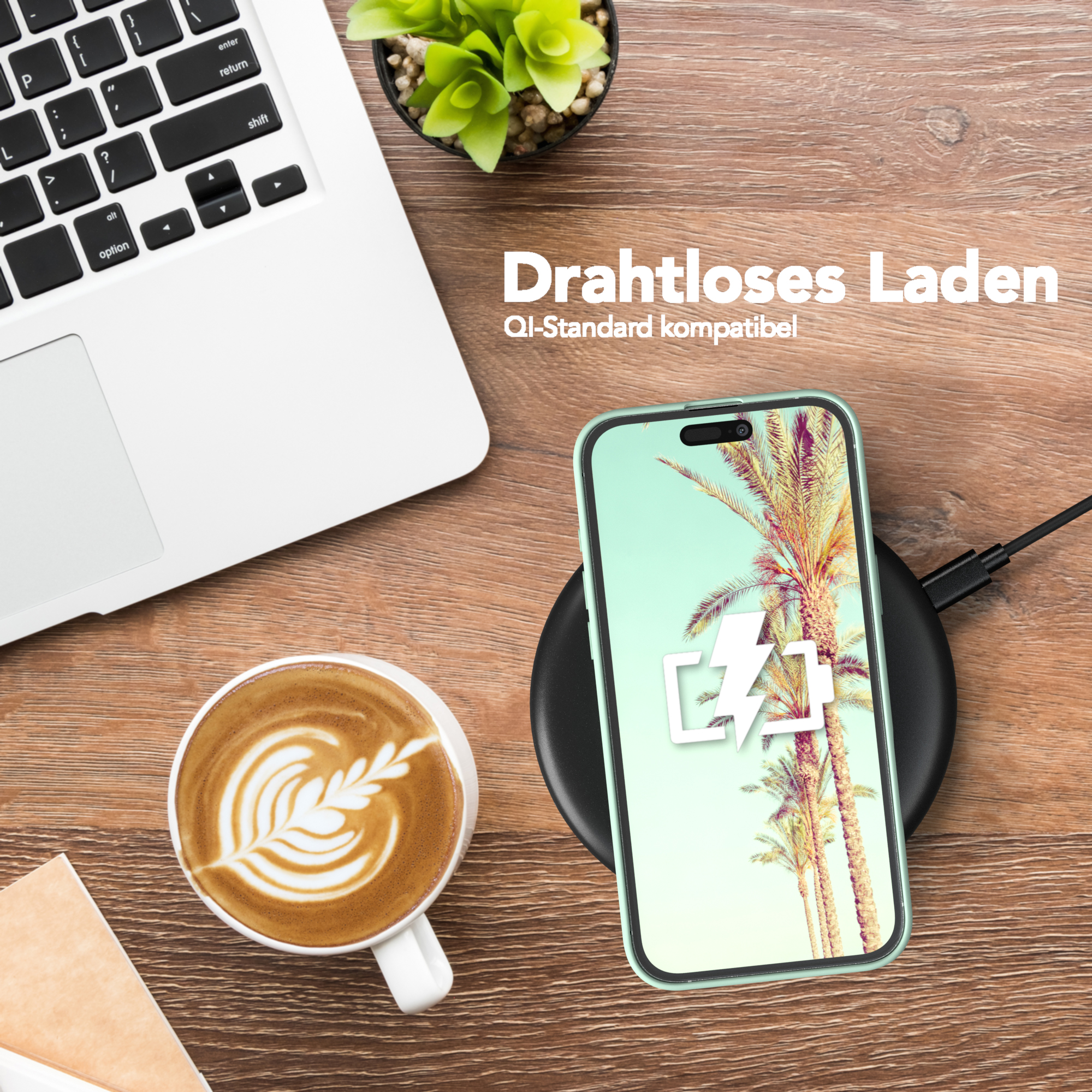 Telefon lädt drahtlos auf einem schwarzen Ladepad. Kaffee und Laptop stehen auf dem Tisch.