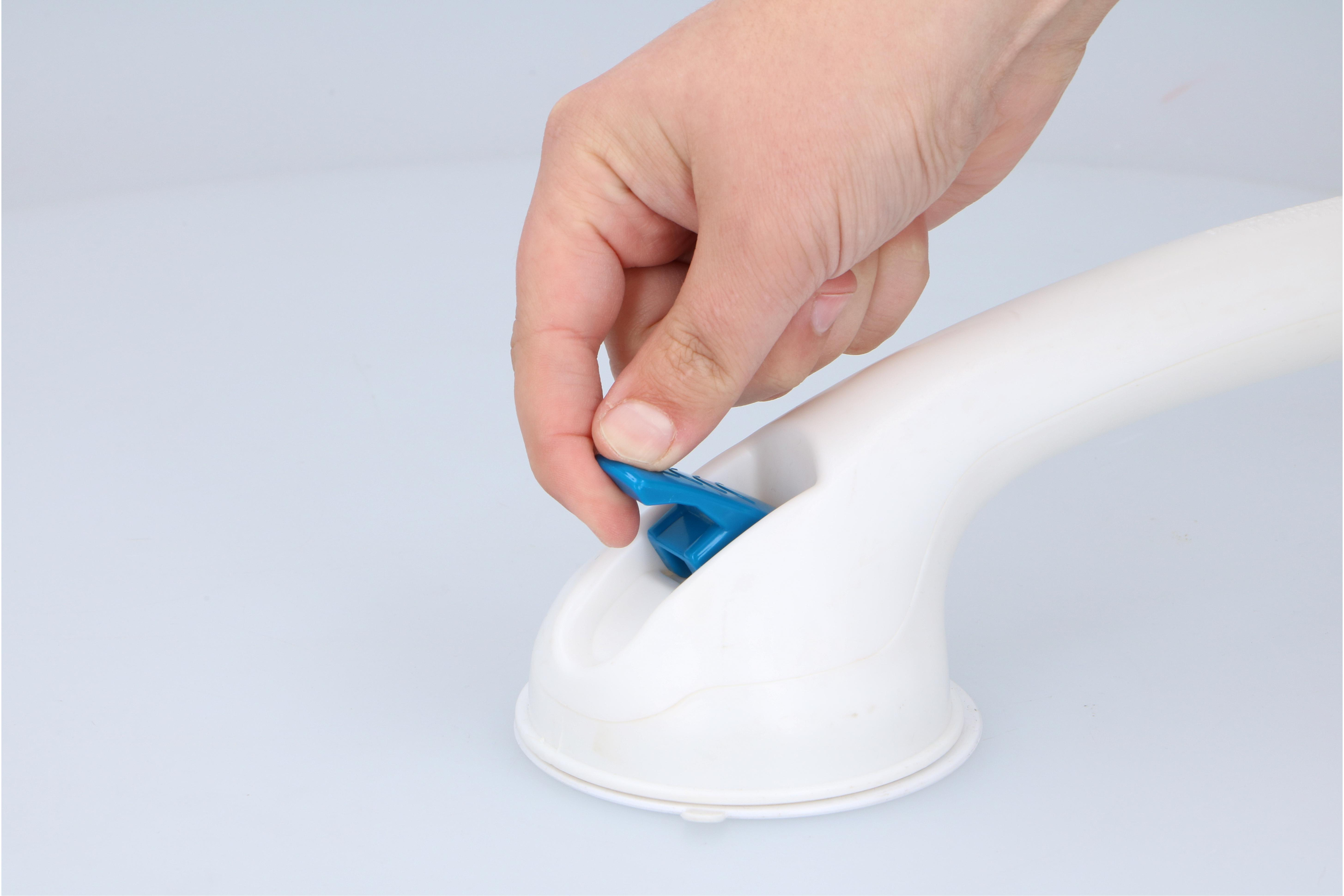 Une main appuyant sur un bouton bleu sur une ventouse en plastique blanc.