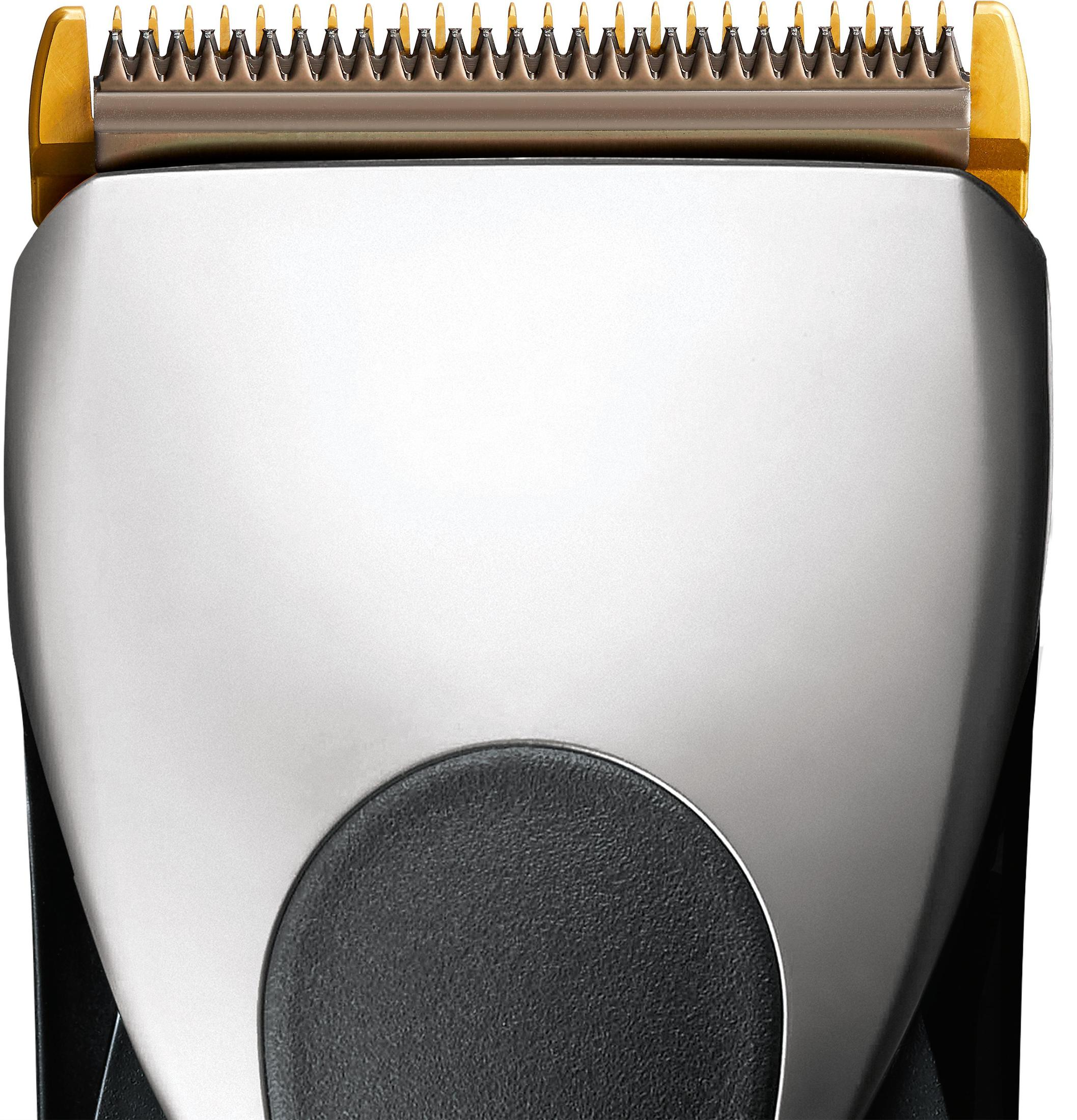 Nahaufnahme eines silber-schwarzen Haarschneidekopfes mit goldenen Zähnen.