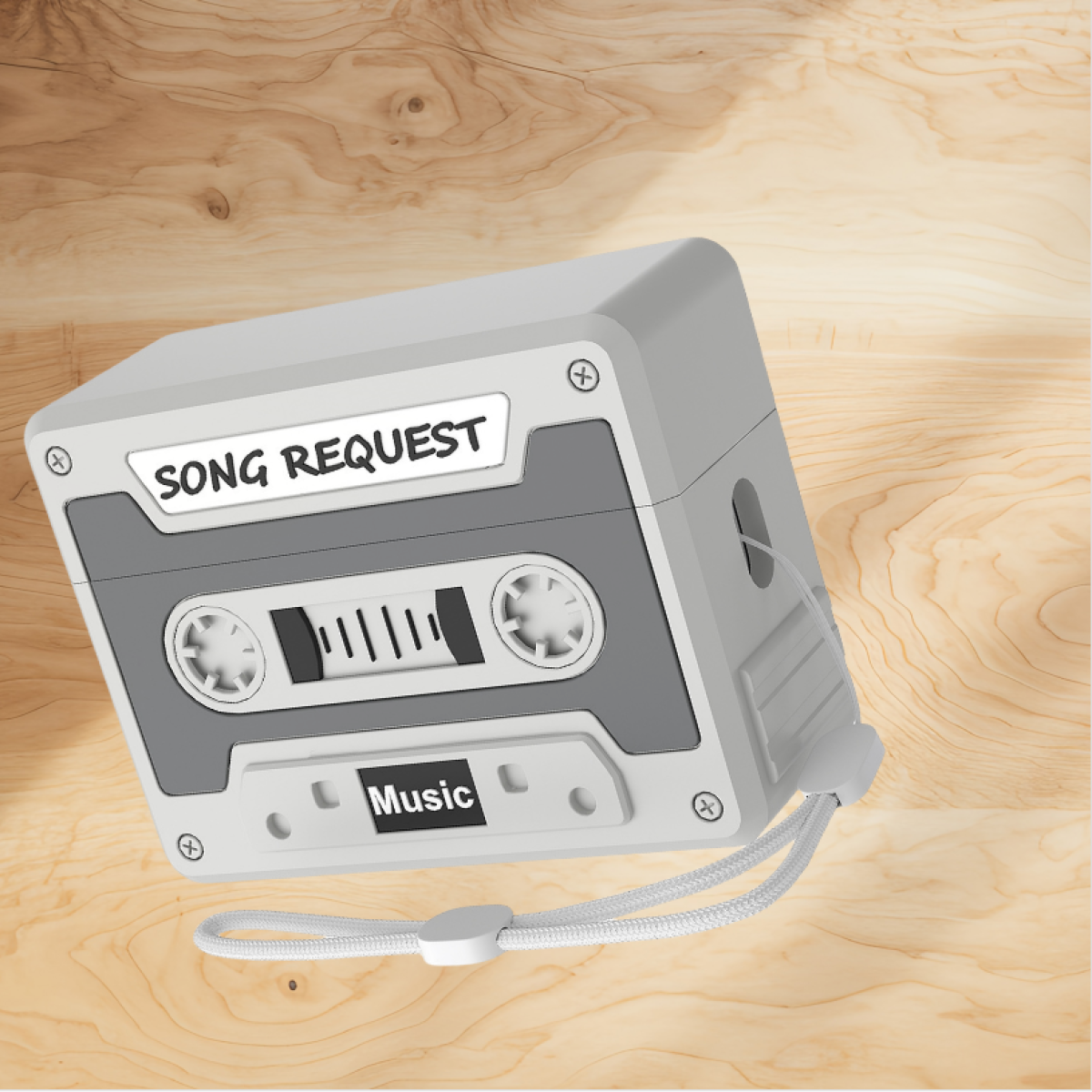 Carcasa de cassette con etiqueta 'SONG REQUEST' y 'Music'. Diseño gris y blanco sobre madera.