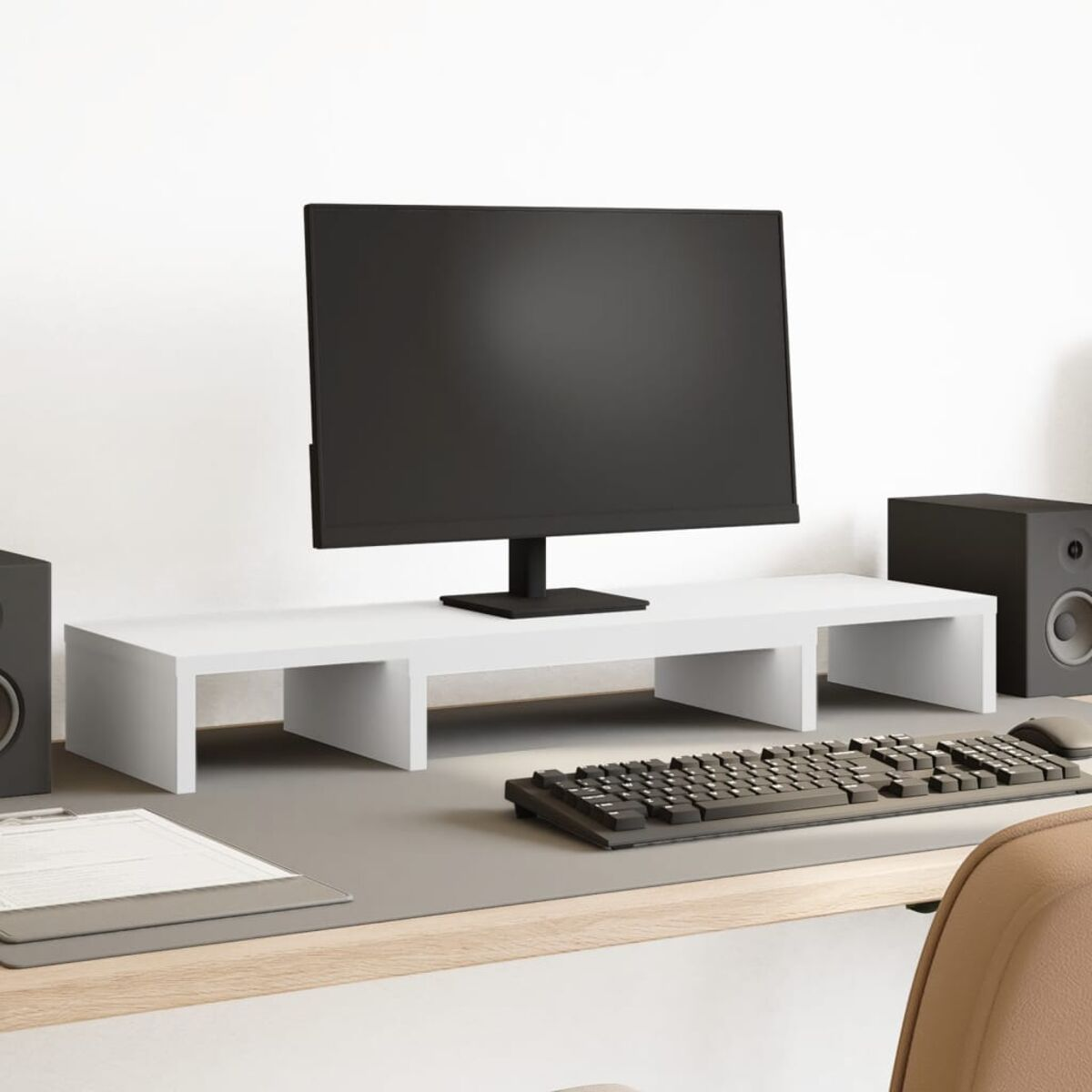 Ein weißer Monitor auf einem weißen Schreibtischständer, mit Tastatur und Lautsprechern.