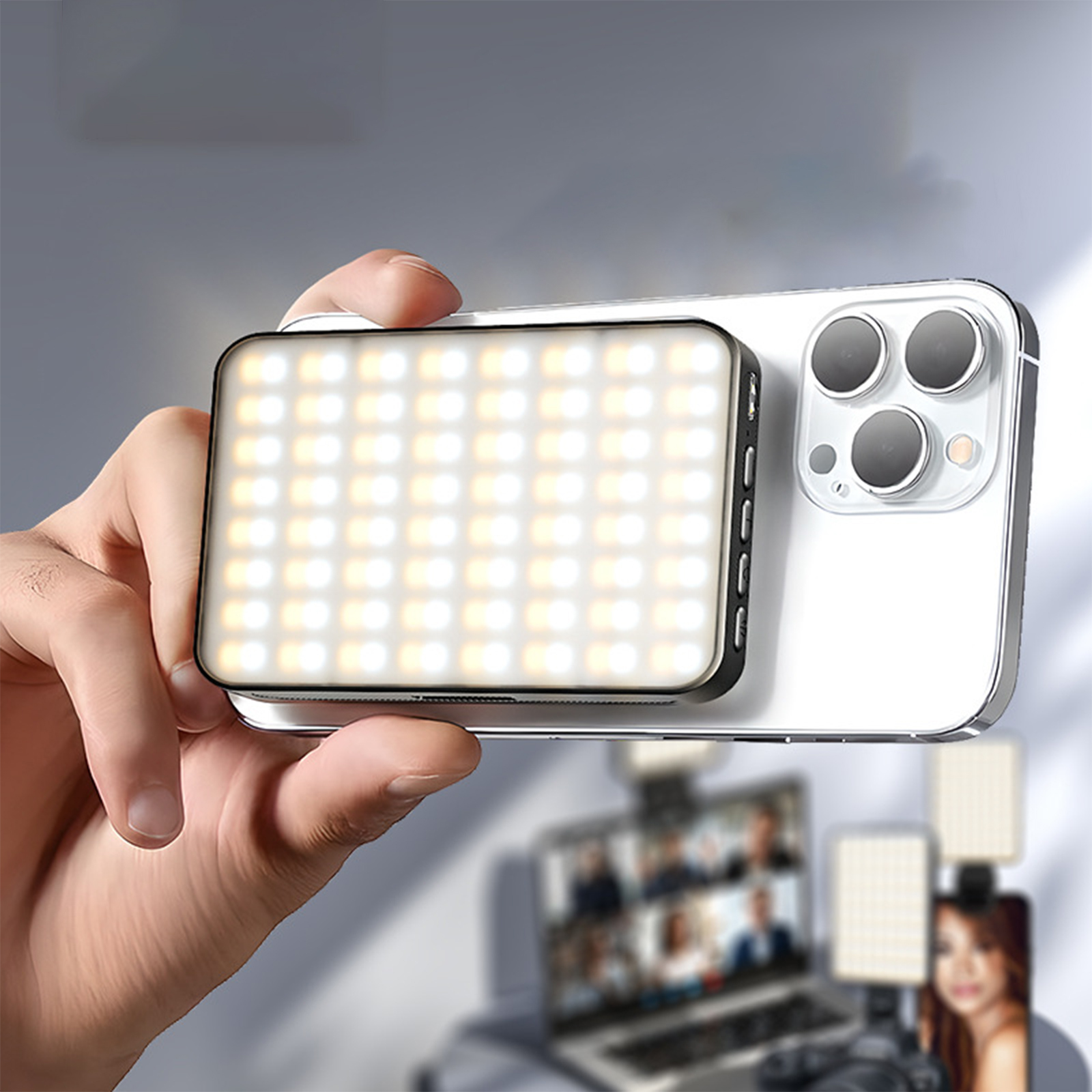 Eine Hand hält ein Telefon mit einem kleinen LED-Licht, im Hintergrund sind Menschen zu sehen.