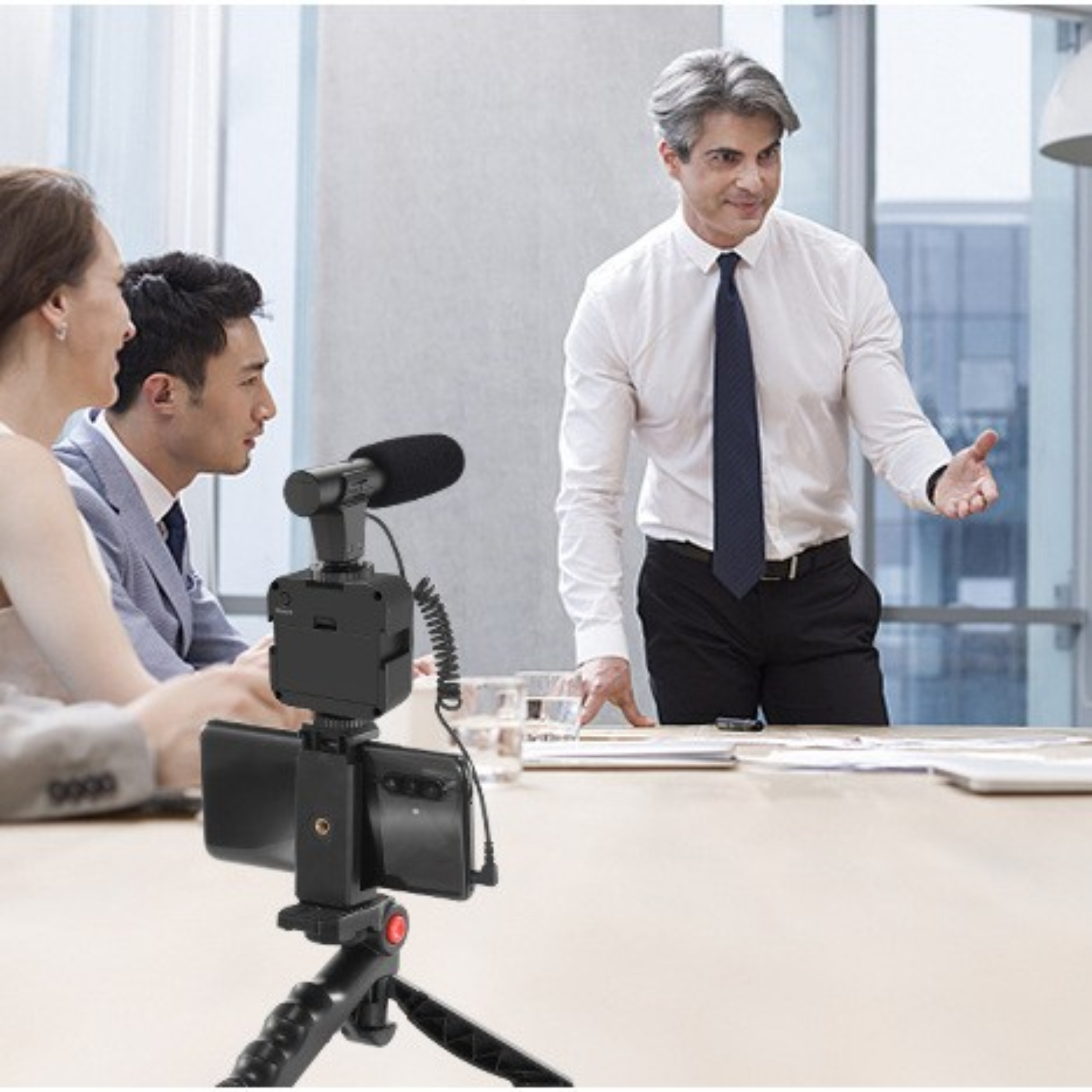 Ein Meeting mit einem Mann, der spricht, und einem Mikrofon vor einem Telefon.