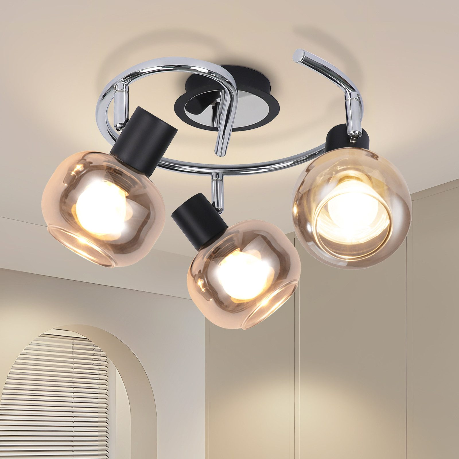 Lampy sufitowe z trzema lampami w kształcie kuli. Lampy są chromowane i czarne z ciepłą poświatą.