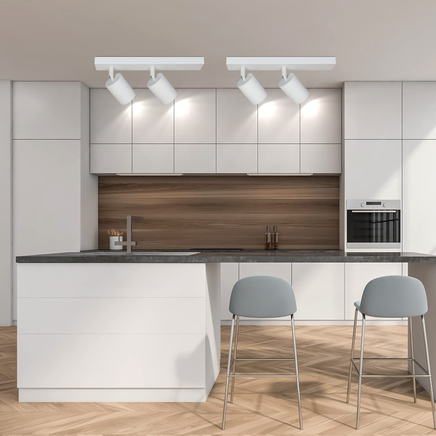 Nowoczesna kuchnia z białymi szafkami, wyspą i dwoma hokerami. Dwa reflektory.