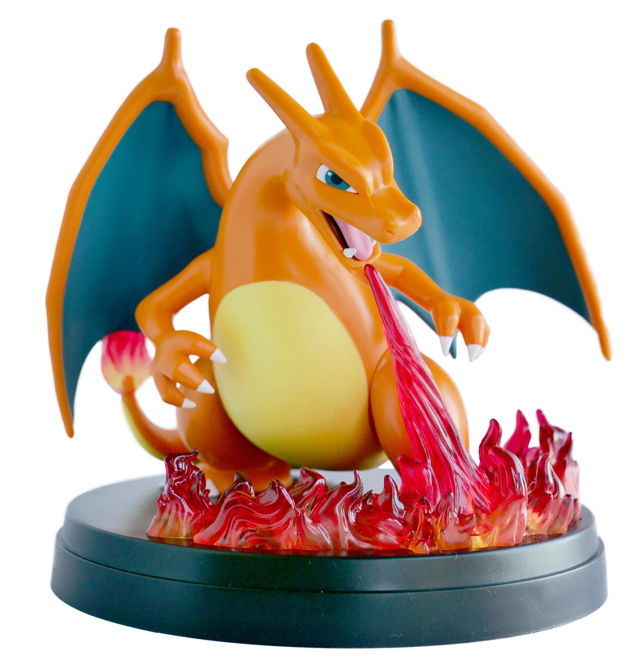 Une figurine de Charizard. Il est orange et a des ailes bleues. Il crache du feu.