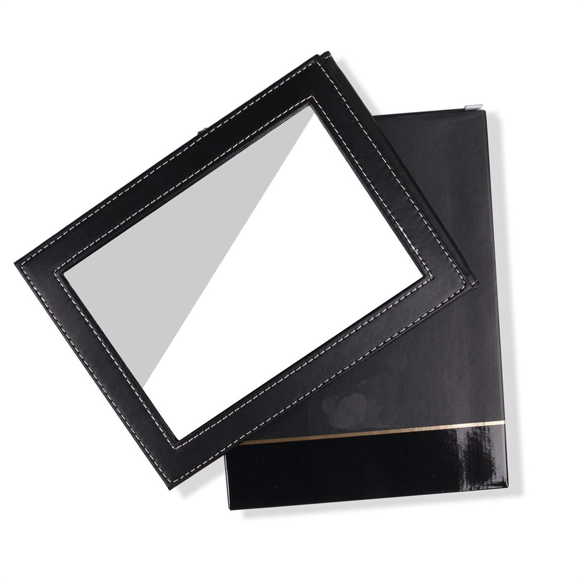 Schwarz-weißer Leder-Fotorahmen, offen auf schwarzer Oberfläche.
