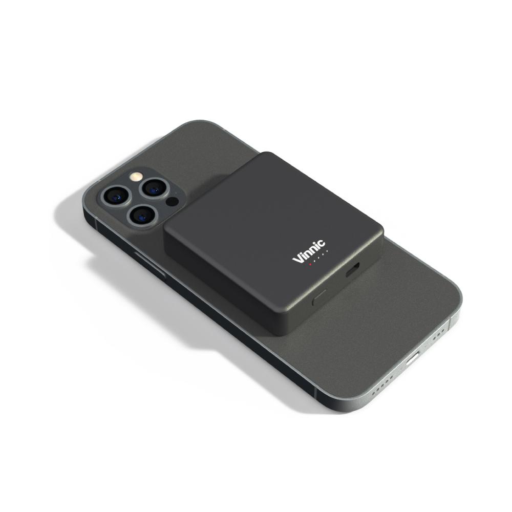 Schwarze Powerbank auf einem schwarzen Telefon. Die Powerbank ist schwarz. Weißer Hintergrund.