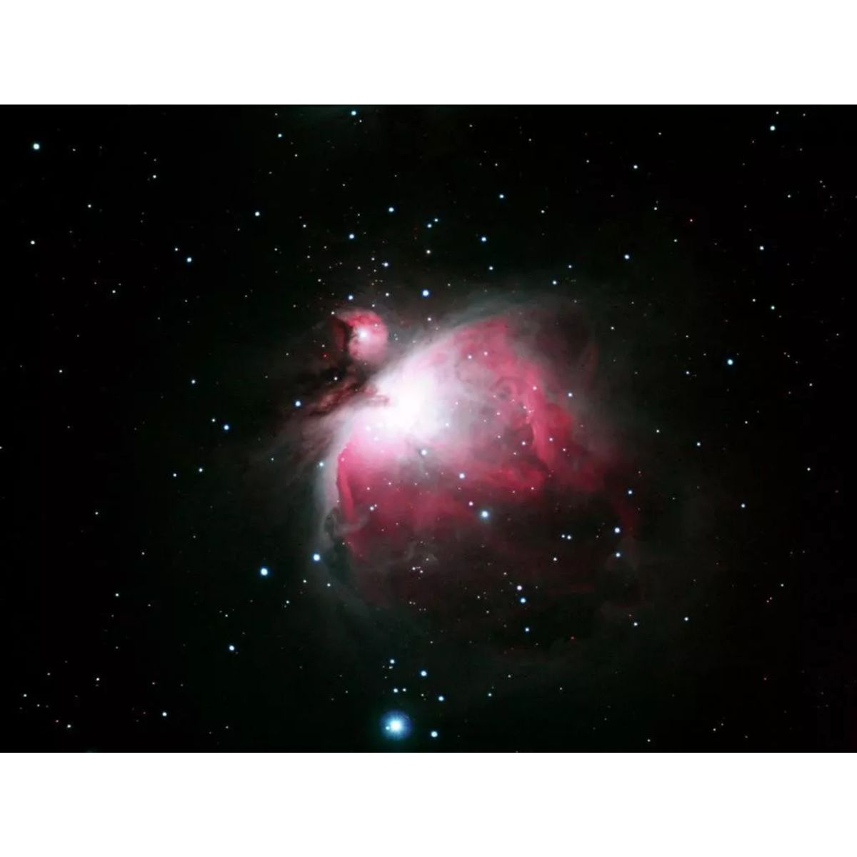 Nebulosa de Orión, una gran nube de gas roja y blanca en un cielo oscuro estrellado.