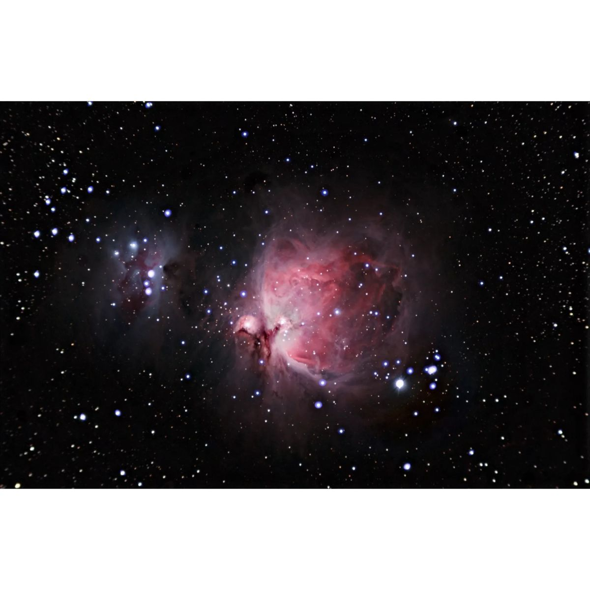 Una nebulosa vibrante en el espacio, con tonos rojos y rosas y muchas estrellas. Fondo oscuro.