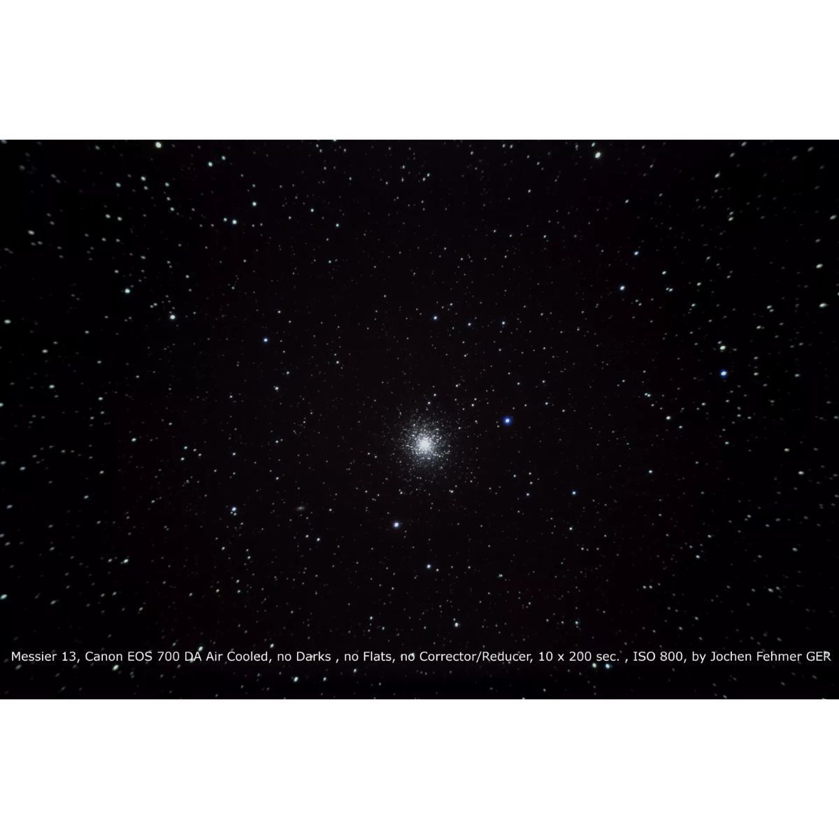 Cielo nocturno con numerosas estrellas. Un cúmulo estelar denso en el centro, con texto en la parte inferior.