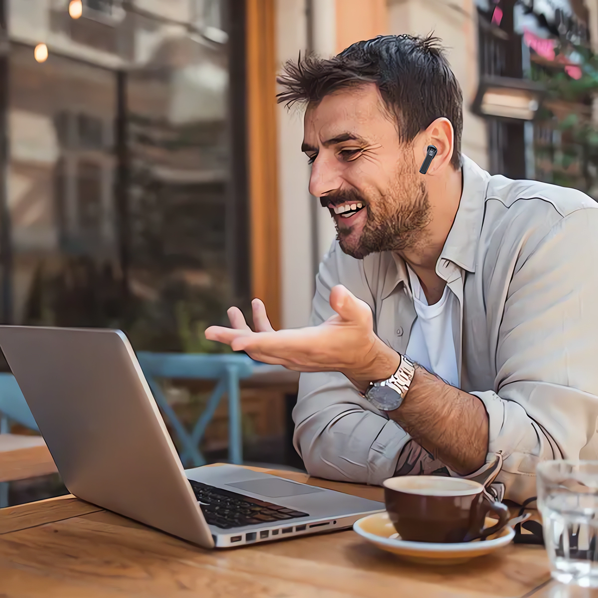 Mann im beigen Hemd telefoniert per Video auf Laptop im Freien, mit Ohrhörer.