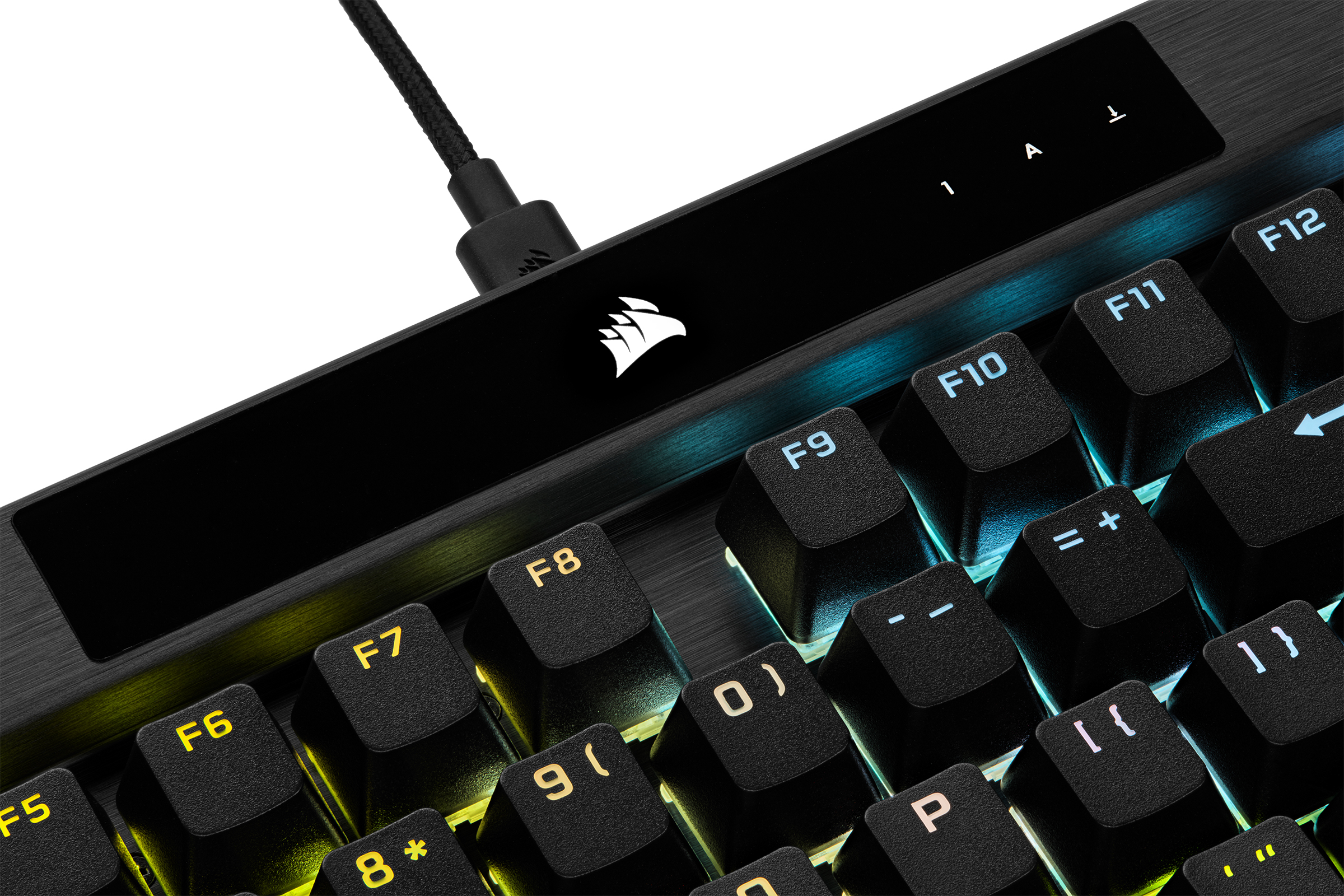 Primer plano de un teclado con teclas iluminadas y un cable negro enchufado.