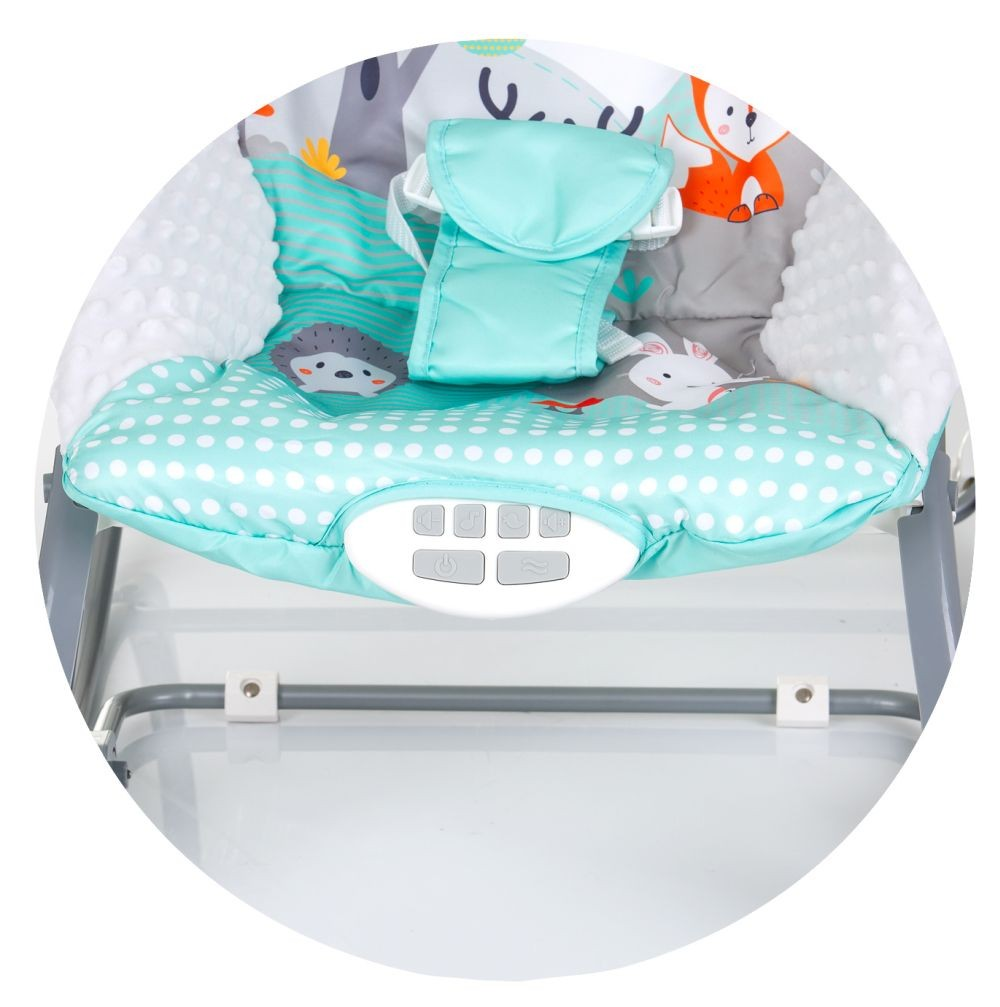 Babywippe mit gemustertem Stoff, mintgrünem Sitz und weißem Rahmen.