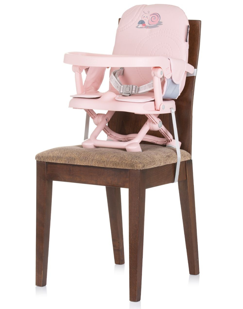 Una trona rosa para bebés en una silla marrón. La silla tiene una bandeja y un diseño de caracol.