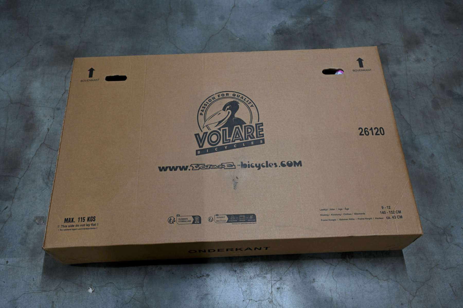 Ein Karton mit der Aufschrift 'VOLARE BICYCLES'. Die Box hat Pfeile und Text auf Niederländisch.