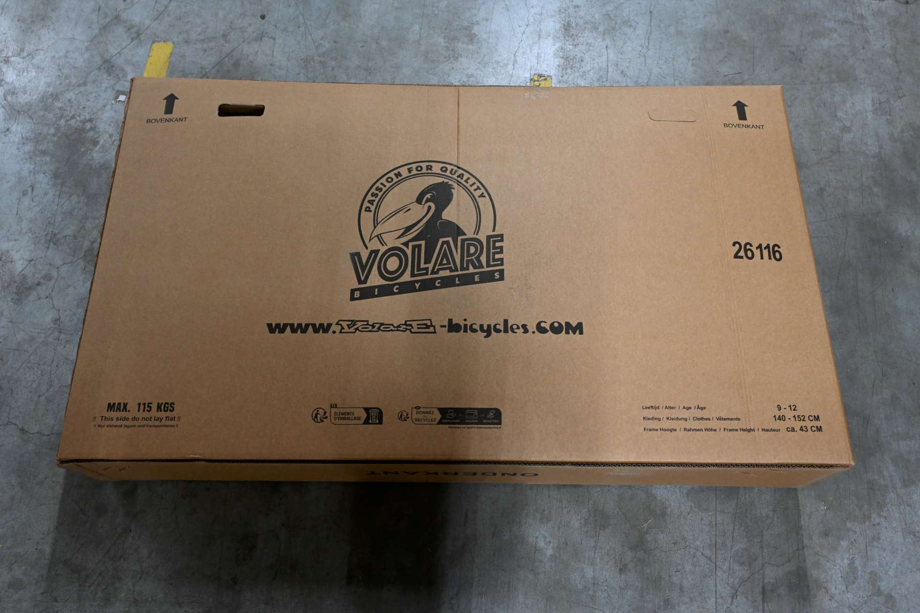Ein Pappkarton mit Text und einem Logo. Es steht 'VOLARE BICYCLES' und 'Passion for Quality'.
