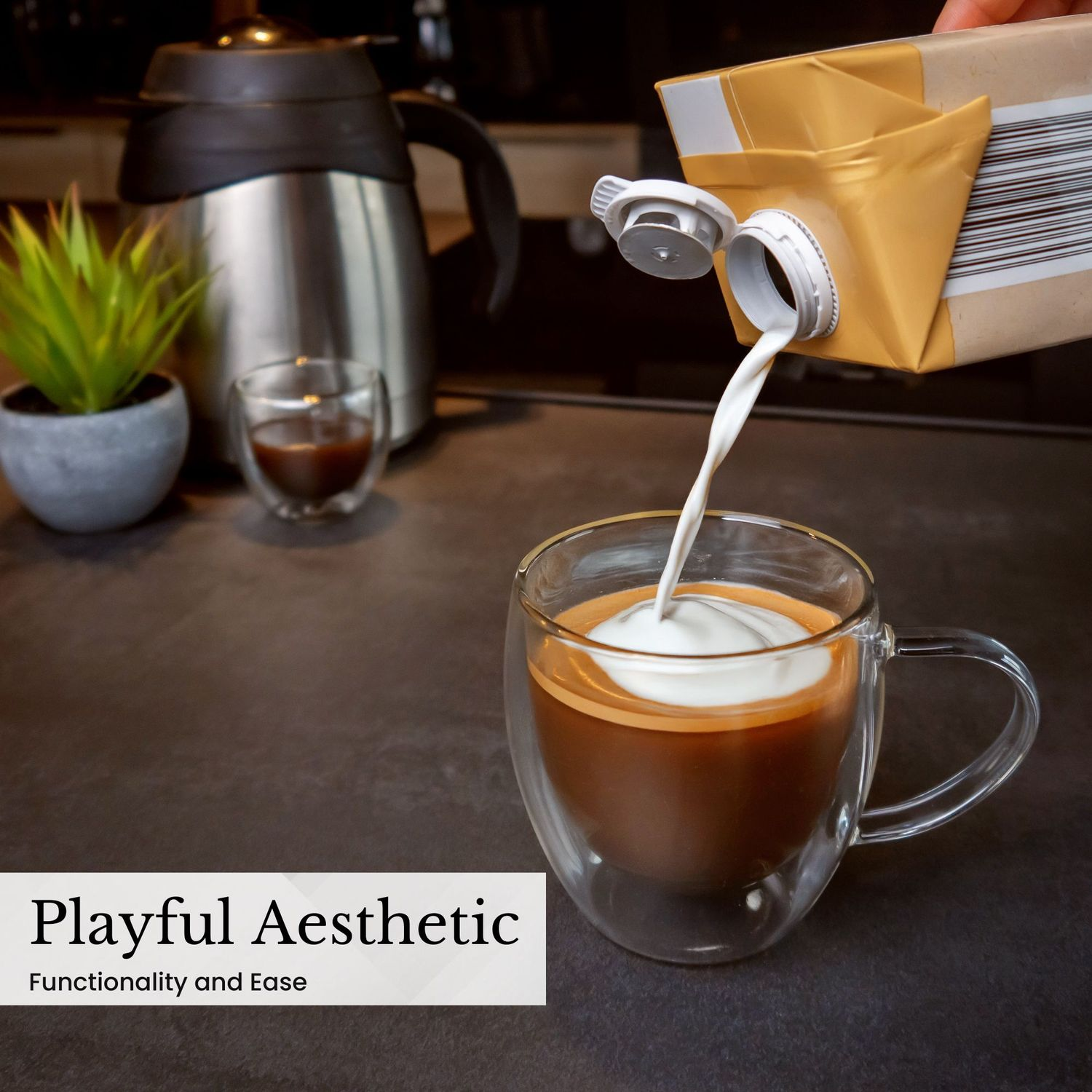 Sahne wird in eine Kaffeetasse gegossen. Eine Pflanze und ein kleines Glas sind im Hintergrund auf dunkler Oberfläche.