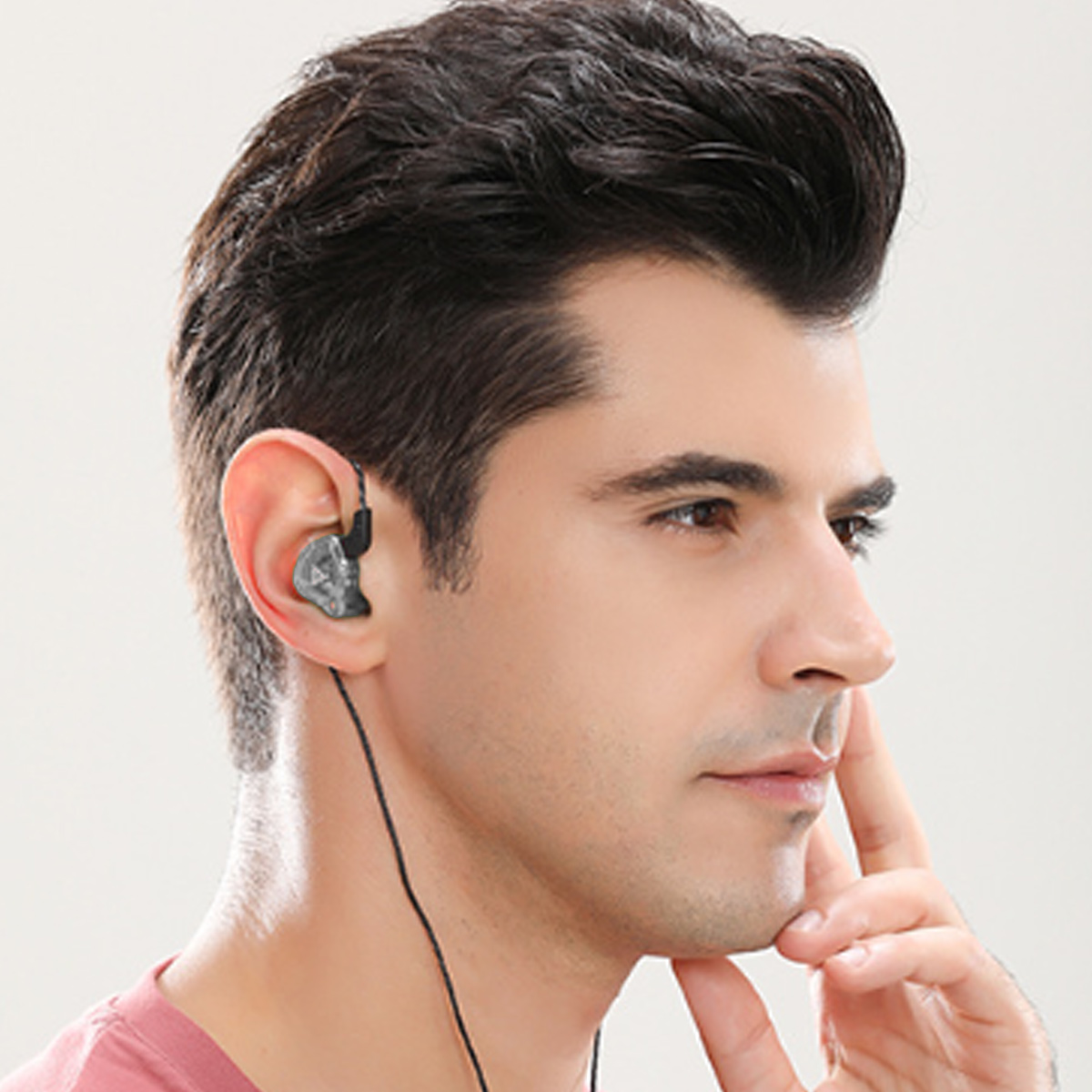 Mann trägt einen In-Ear-Monitor. Der Monitor ist klein und grau, mit einem schwarzen Kabel.