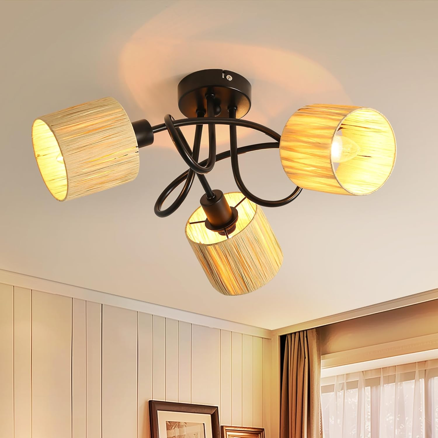 Lampa sufitowa z trzema abażurami, czarną ramą i światłem wewnątrz.