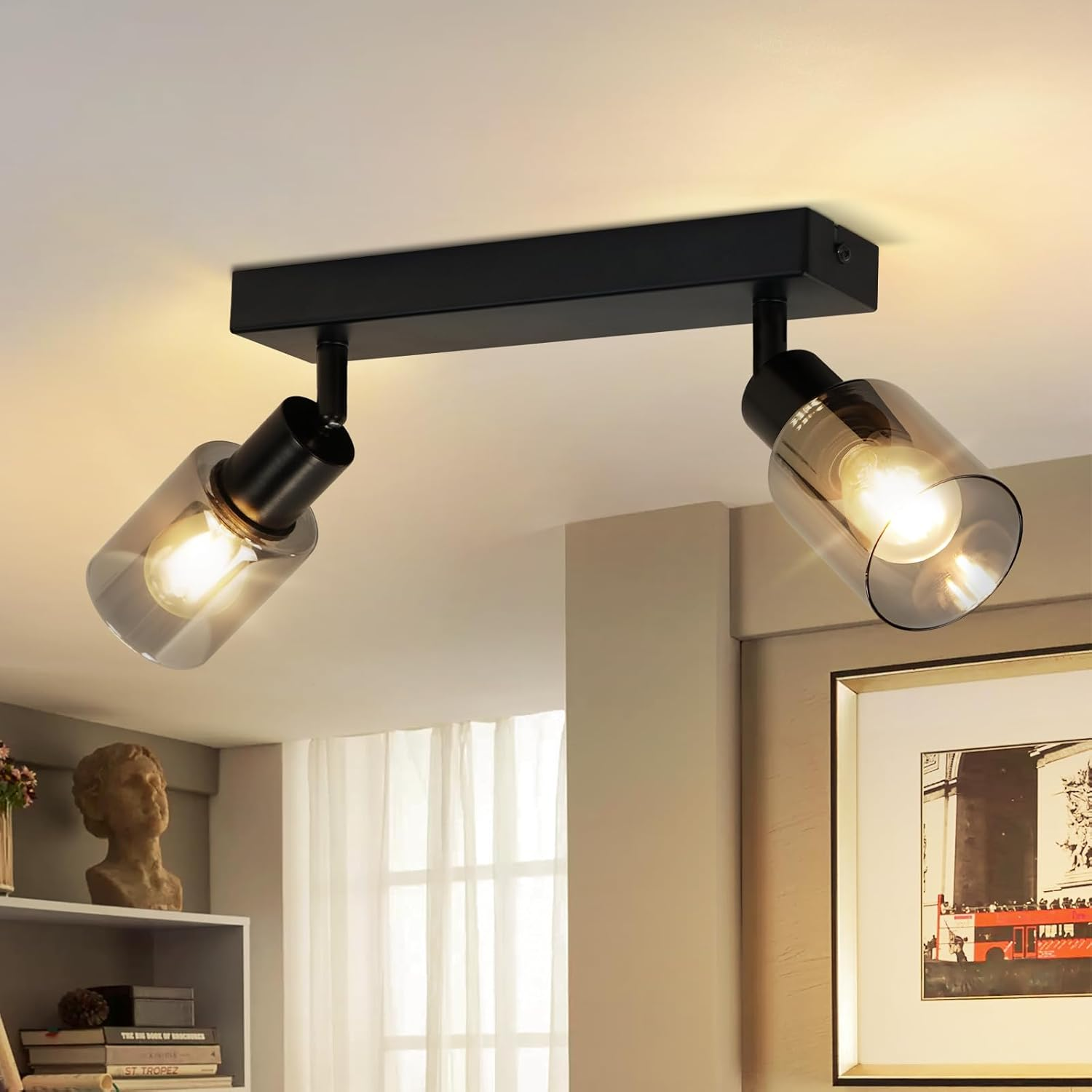 Dwa czarne reflektory z kloszami ze szkła na czarnym pasku, zamontowane na białym suficie.