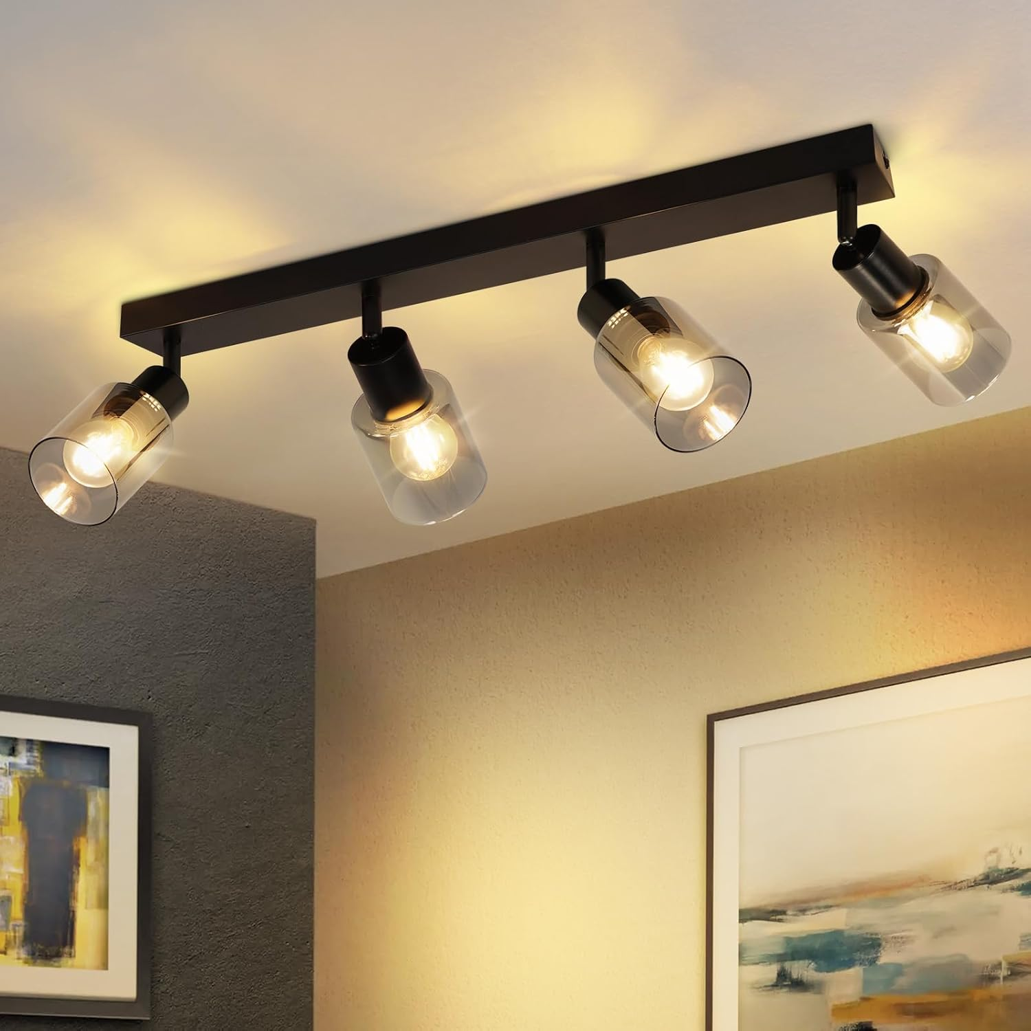 Czarne reflektory sufitowe, z czterema regulowanymi głowicami. Żarówki są widoczne. Tło to beżowy sufit.