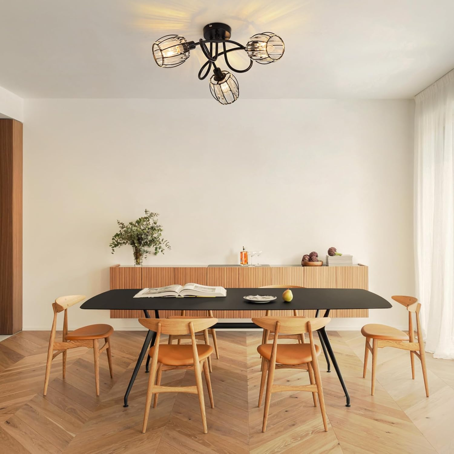 Jadalnia z czarnym stołem, drewnianymi krzesłami i lampą z czterema żarówkami.