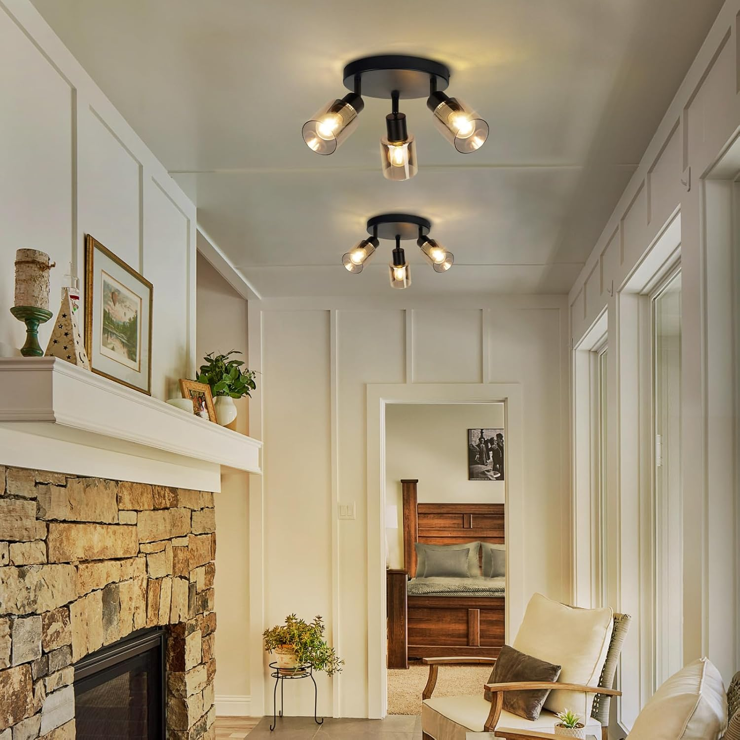 Salon z kominkiem, dwoma lampami sufitowymi, drzwiami i białą ścianą.