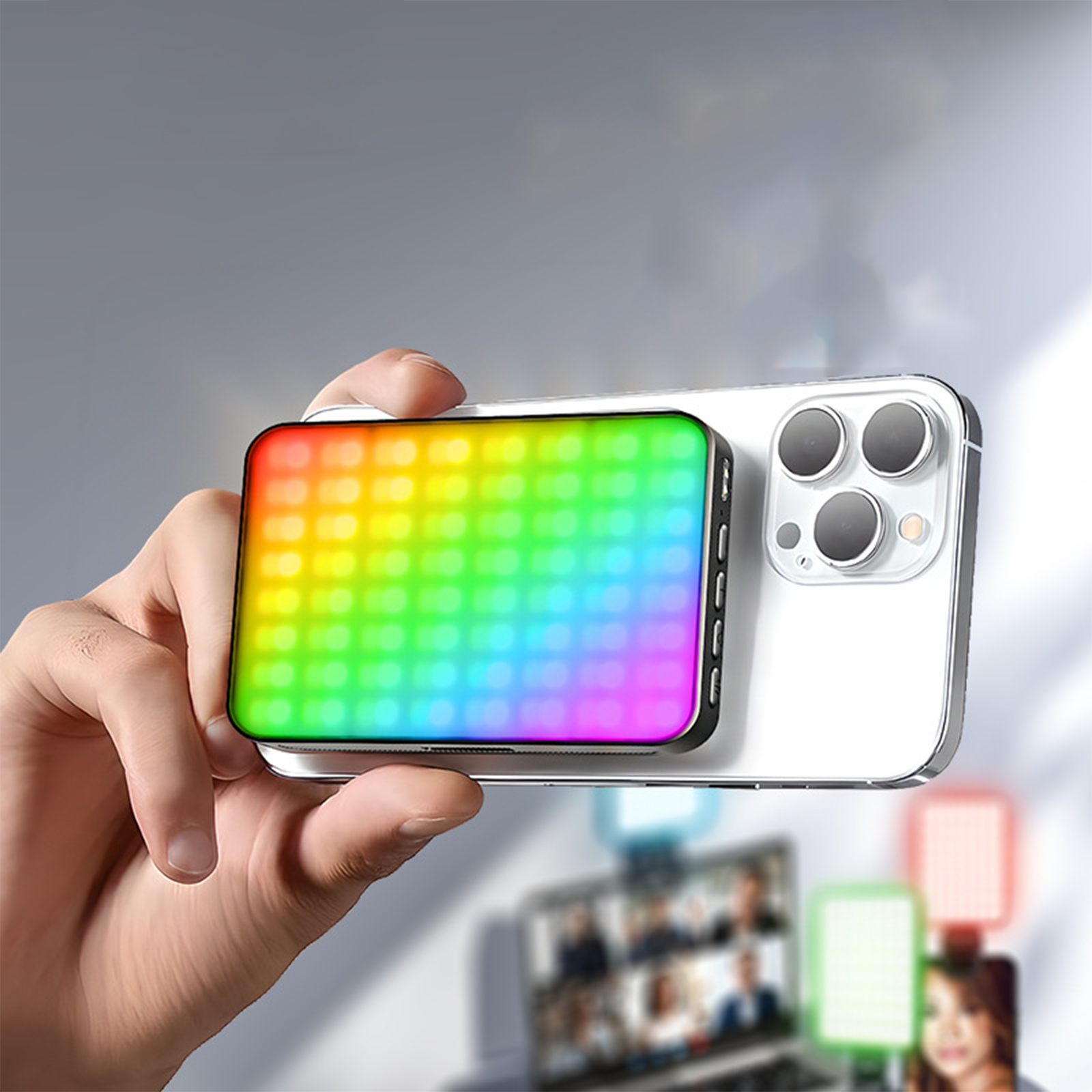 Eine Hand hält ein Smartphone mit einem farbenfrohen LED-Lichtpaneel. Andere Geräte sind sichtbar.